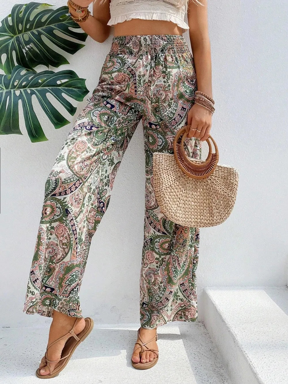 Trendy Printed Wide Leg Pants with Tied Detail, showcasing a fashionable print and paired with a straw bag. Ideal for casual or chic outings, crafted from 100% opaque polyester.