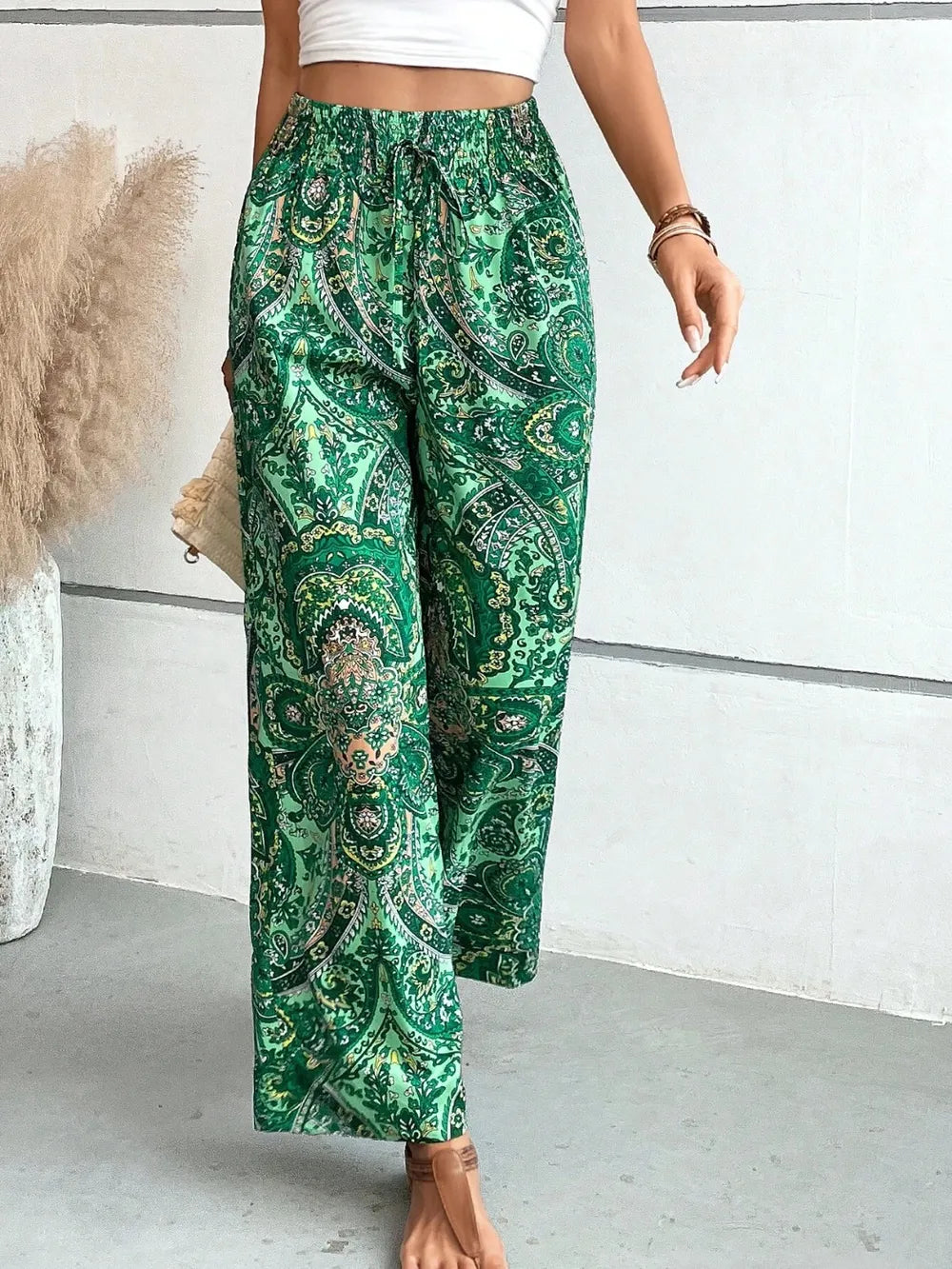 Trendy Printed Wide Leg Pants with Tied Detail captured in motion, highlighting the soft and flowy fabric in a beautiful green paisley pattern, ideal for style and comfort.