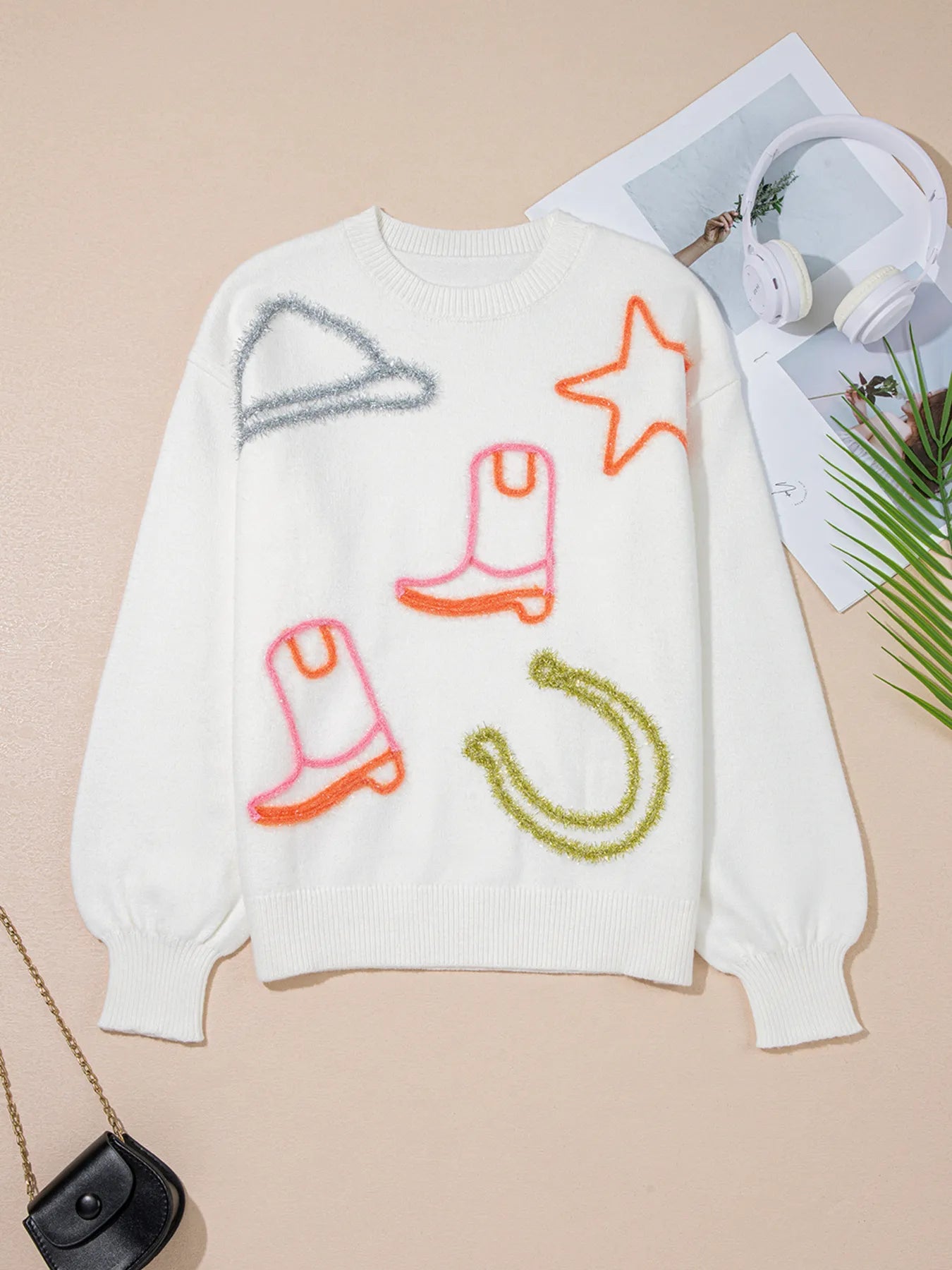 Stylish Western Style Knit Crew Neck Sweater with Horseshoe Star & Slightly Stretchy Fabric, displayed on a flat surface showcasing its vibrant graphic designs including boots and a star.