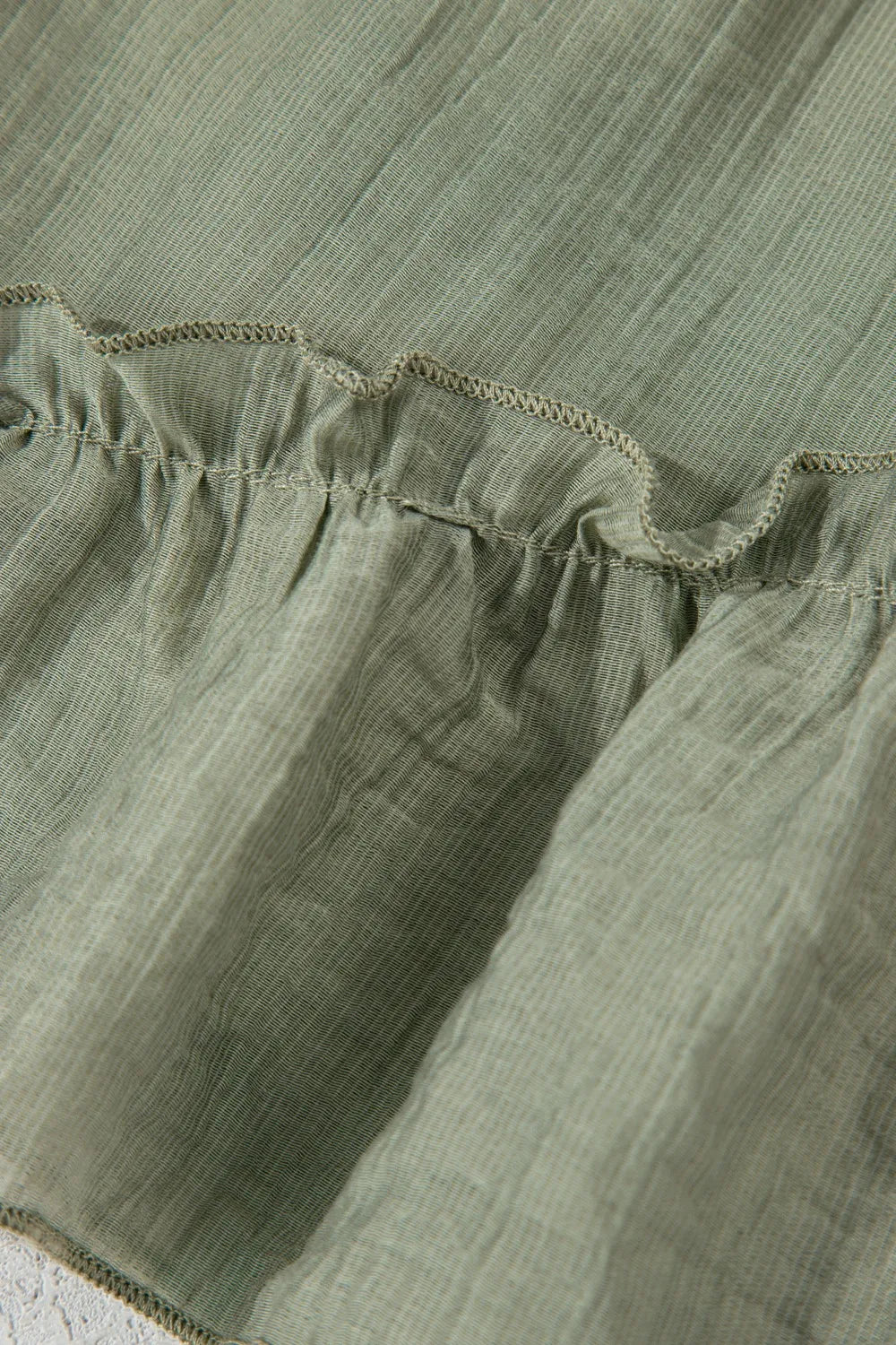 Close-up view of the textured fabric and ruffle detailing of the Tie Waist Ruffle Hem Shorts, showcasing quality craftsmanship and stylish design.