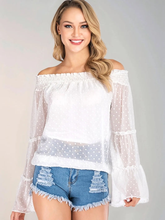 Trendsi Swiss Dot Off-Shoulder Blouse featuring a sheer design, smocked detailing, and tiered sleeves, perfect for a casual chic style paired with denim shorts.