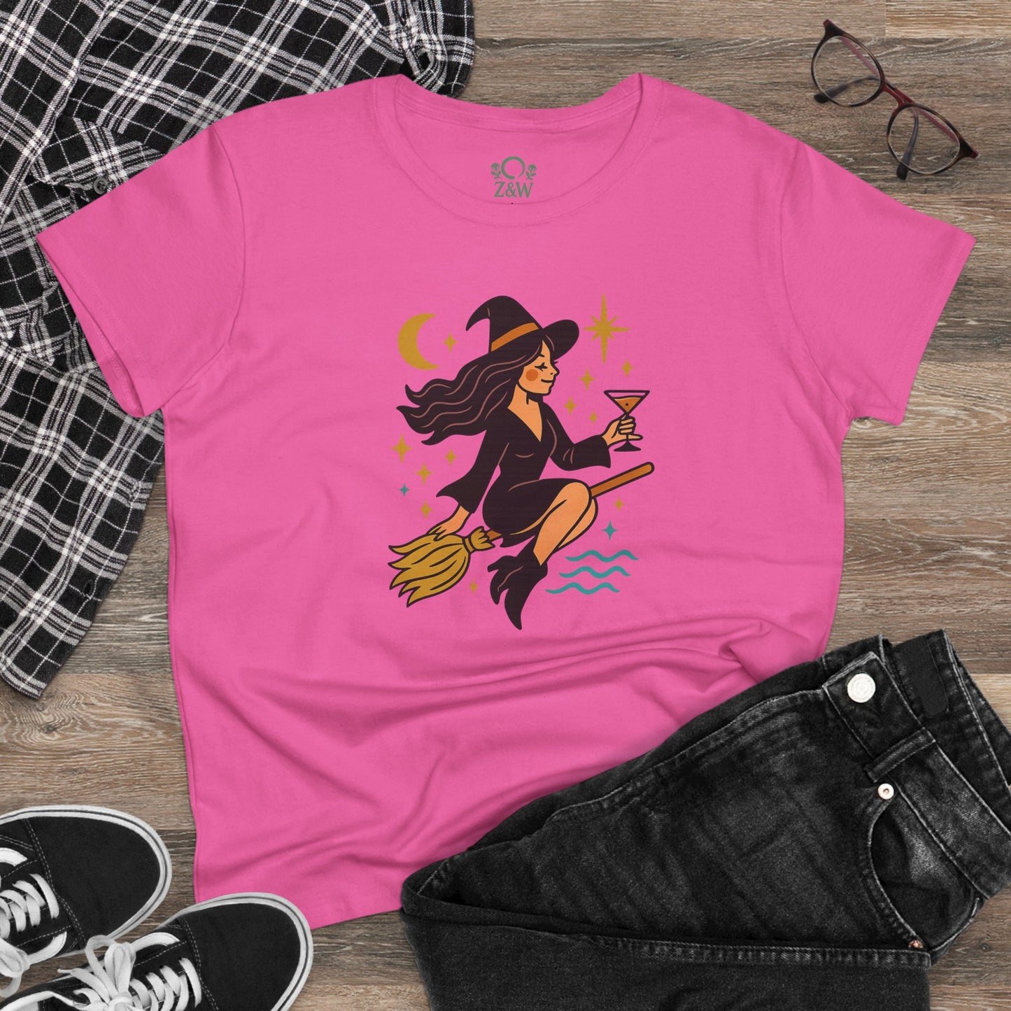 Witchy Night Out Tee displayed with casual outfit items, featuring a playful witch illustration, made from 100% cotton for a trendy look.
