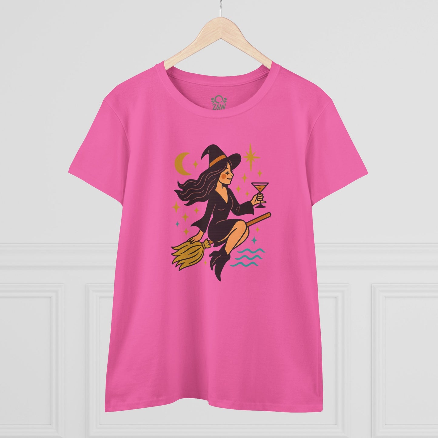 Front view of the Witchy Night Out Tee, highlighting the charming witch illustration with cocktail, set against a bright pink background.