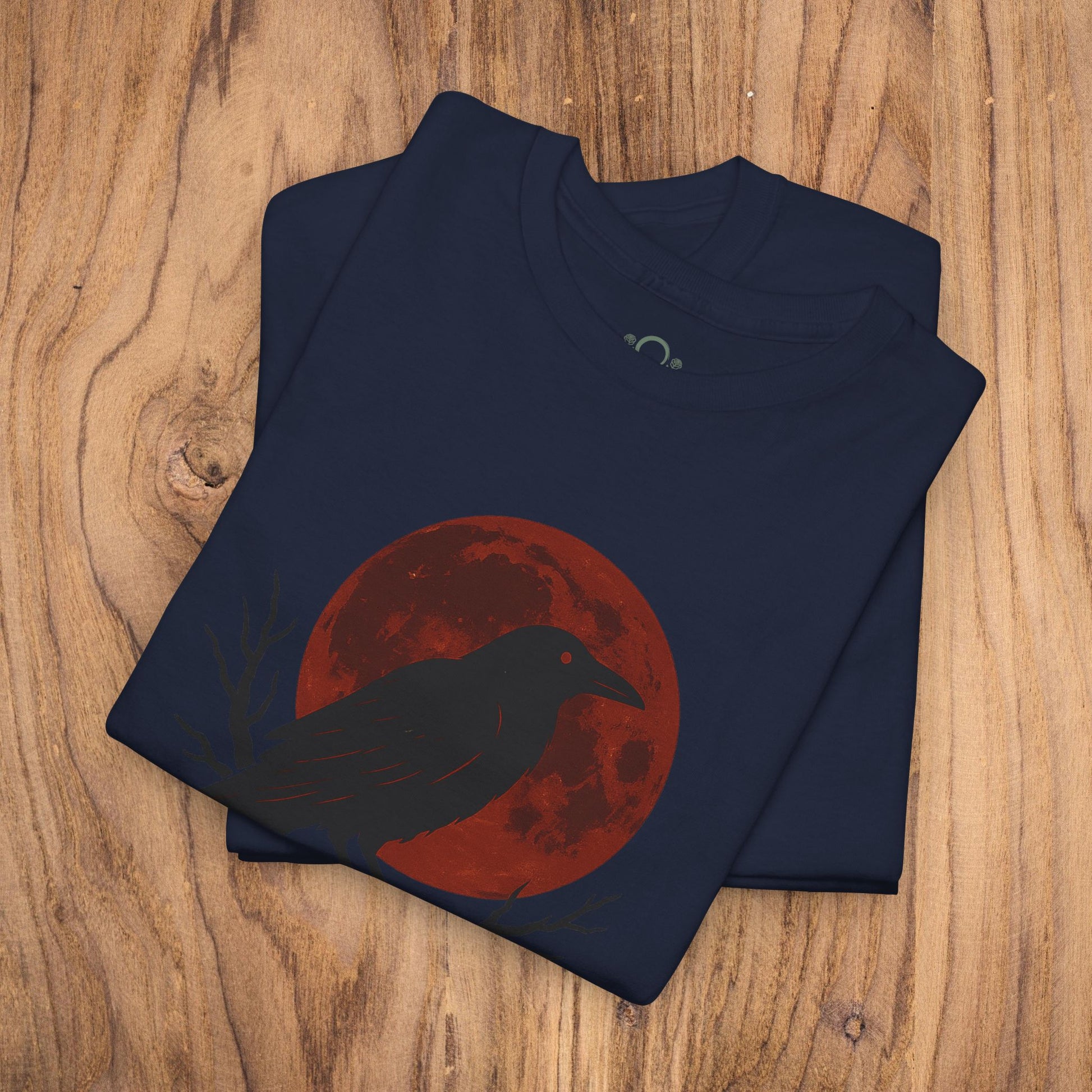 Gothic Raven T-Shirt emphasizing a raven silhouette in front of a red moon, a great choice for Halloween. Made from heavy cotton, this unique spooky gift complements any casual fall wardrobe.