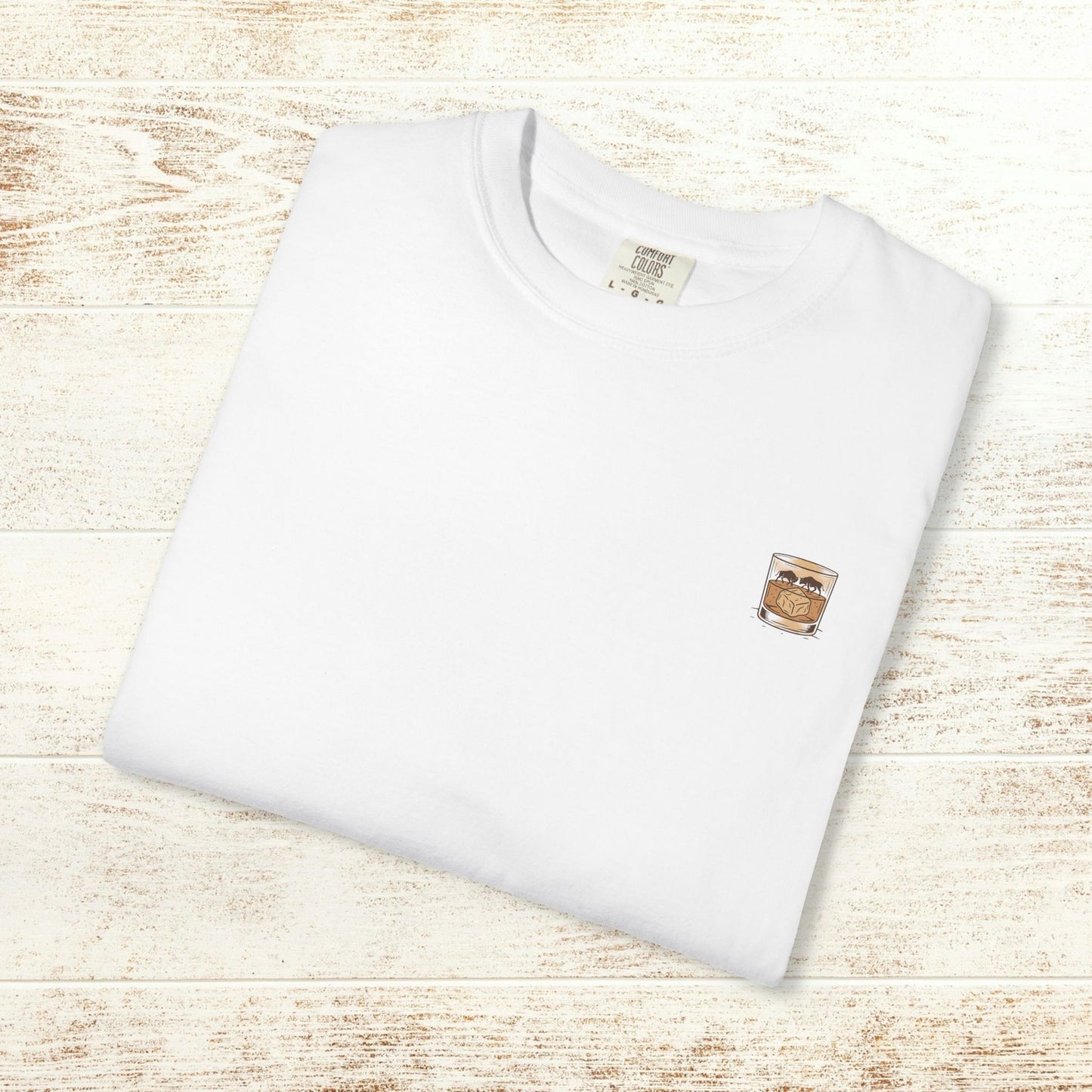 Front view of the Rodeo On The Rocks Tee folded neatly, displaying a unique chest graphic of a drink; crafted in durable and soft fabric.