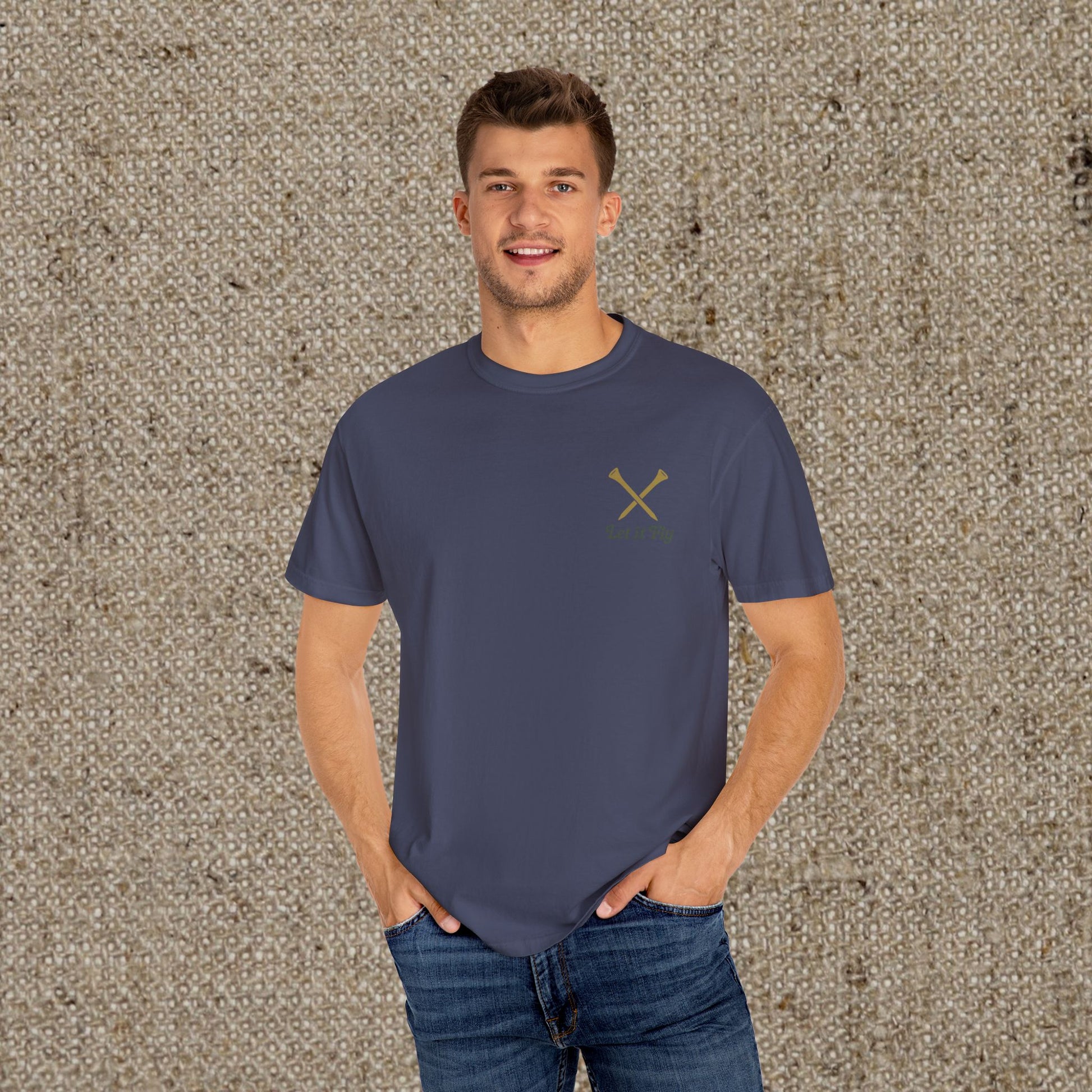 Model wearing the Tee It High Let It Fly Graphic Tee in navy, showcasing a fitted design with crossed clubs, ideal for casual golfing or everyday wear.