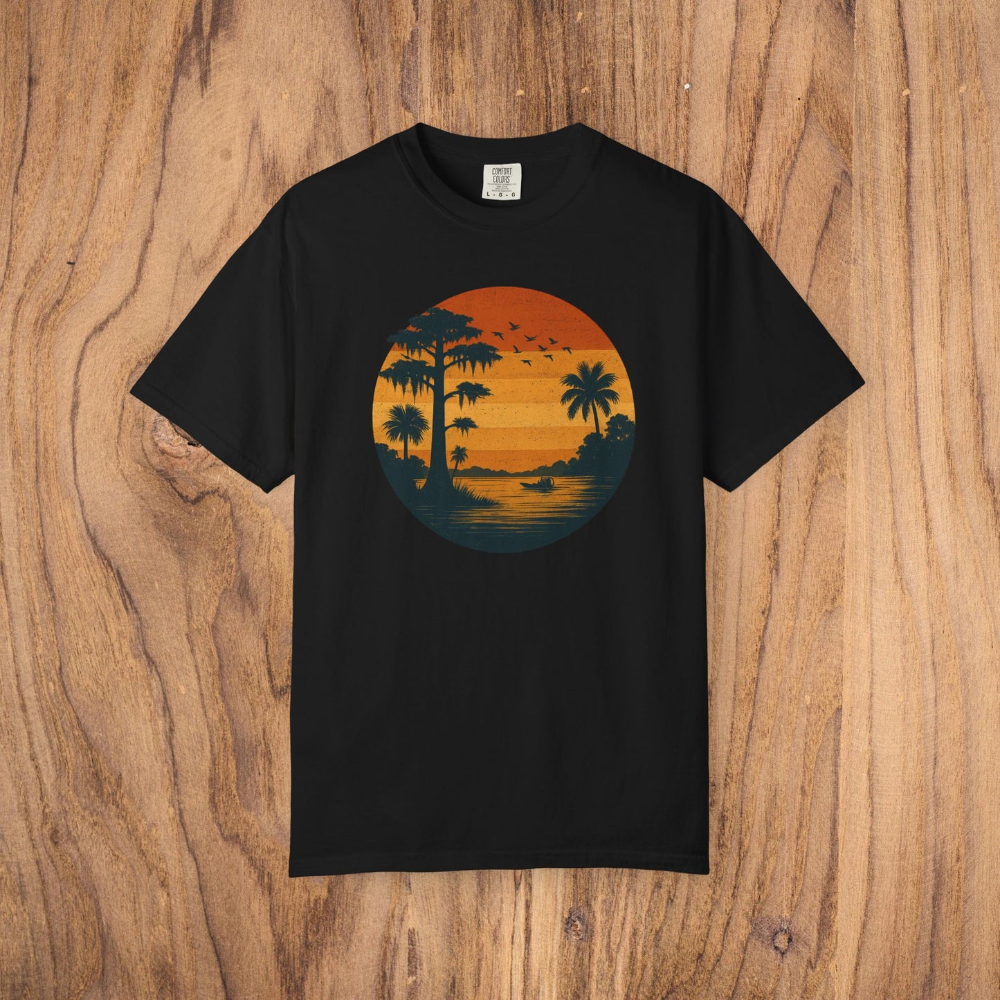 Unisex Garment-Dyed Sunset Tee in black displaying a picturesque sunset scene with palm trees, a stylish choice for any casual setting, available in sizes S to 4XL.