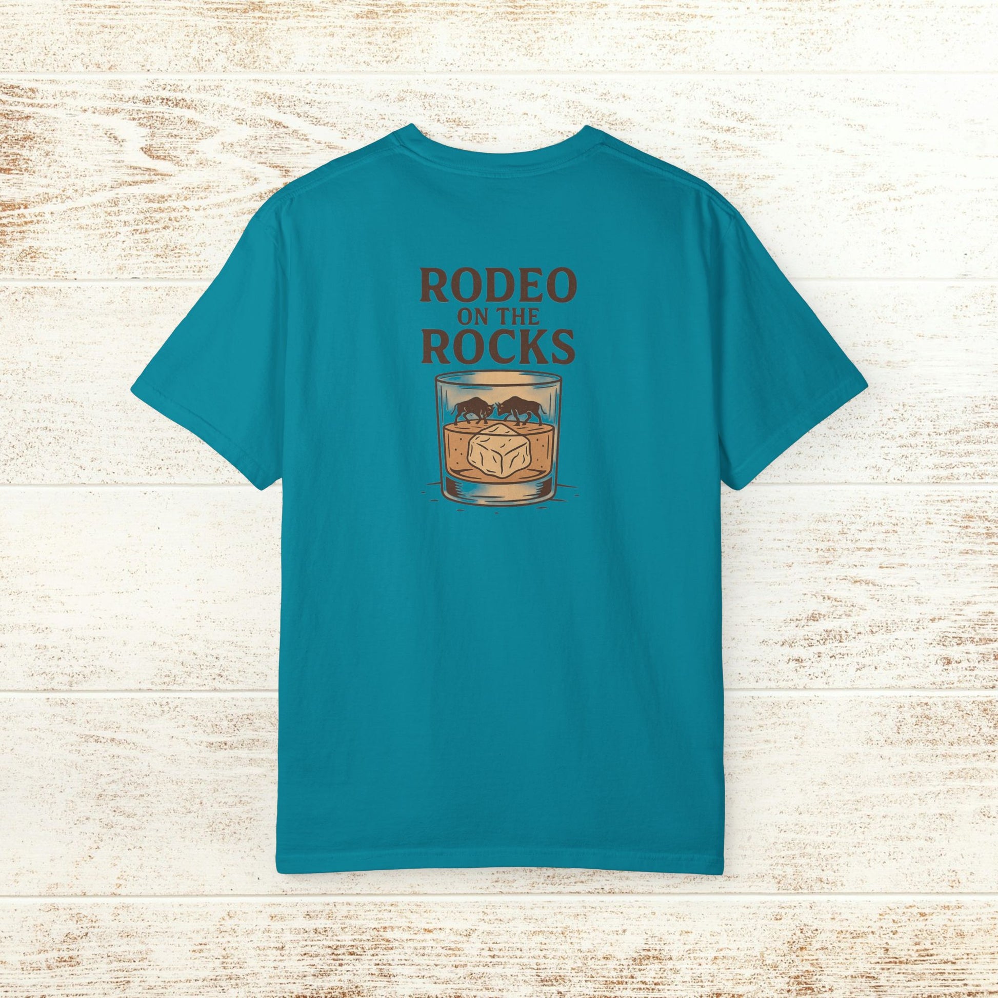 Back view of the Rodeo On The Rocks Tee in vibrant teal, featuring the unique logo design with the text 'RODEO ON THE ROCKS' above a glass with ice, perfect for stylish summer outings.