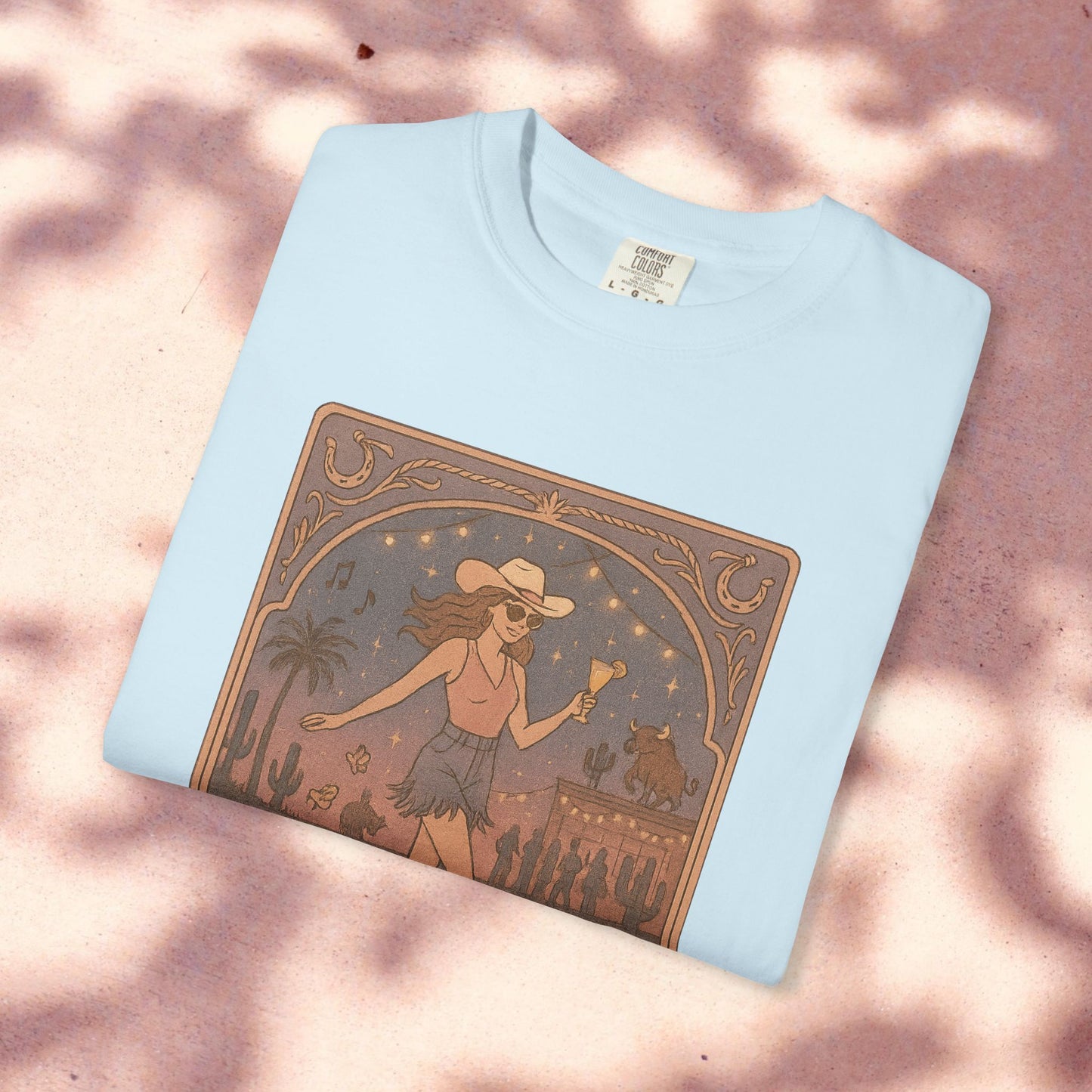 Line Dancer Tarot Tee made from soft cotton, presented in a light sky blue, showcasing a unique artwork of a dancing woman with a cowboy hat. This tee, available in sizes S-4XL, is ethically made for a blend of fashion and comfort.