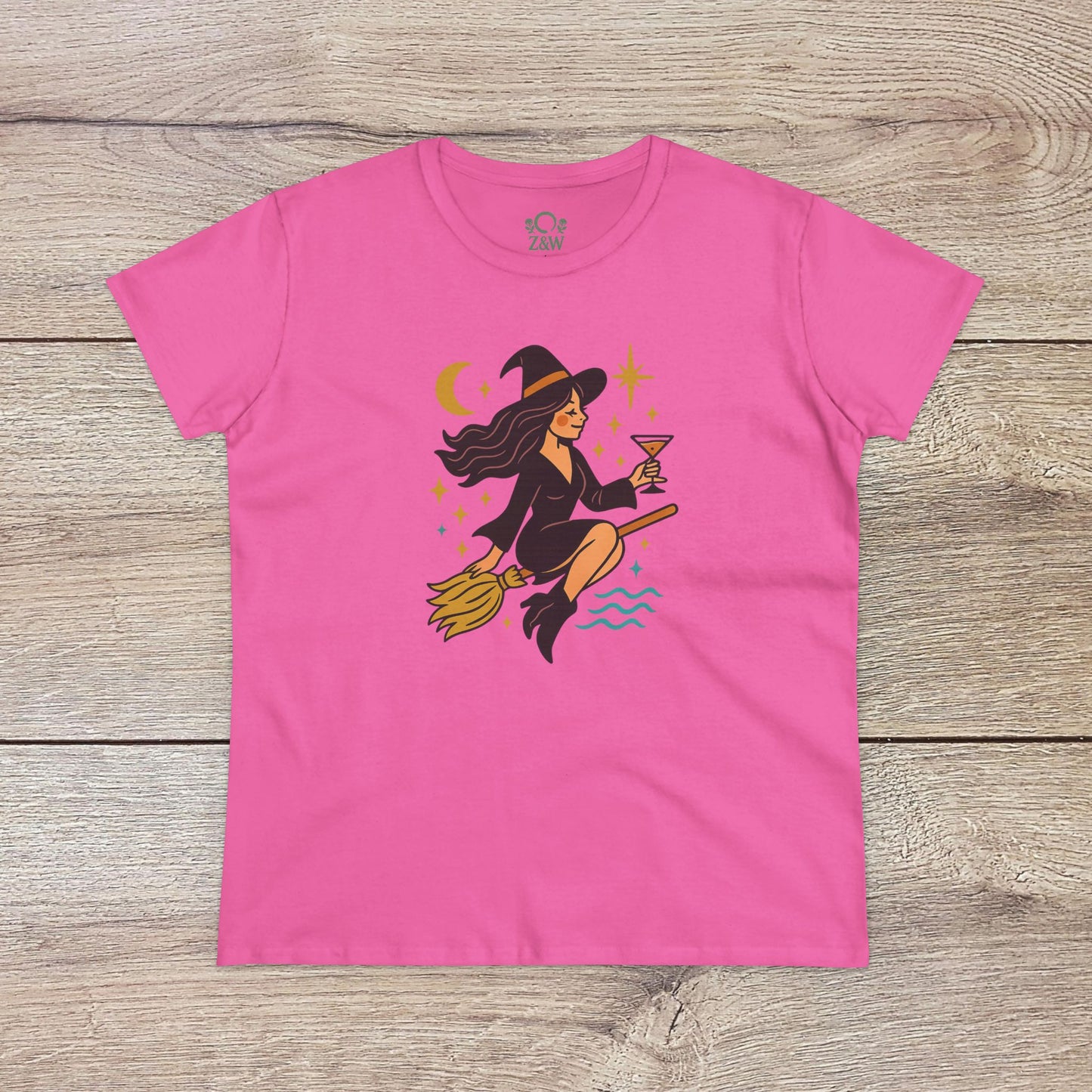 Witchy Night Out Tee in vibrant pink featuring a whimsical witch holding a cocktail while flying on a broomstick, crafted from 100% cotton for comfort and style.
