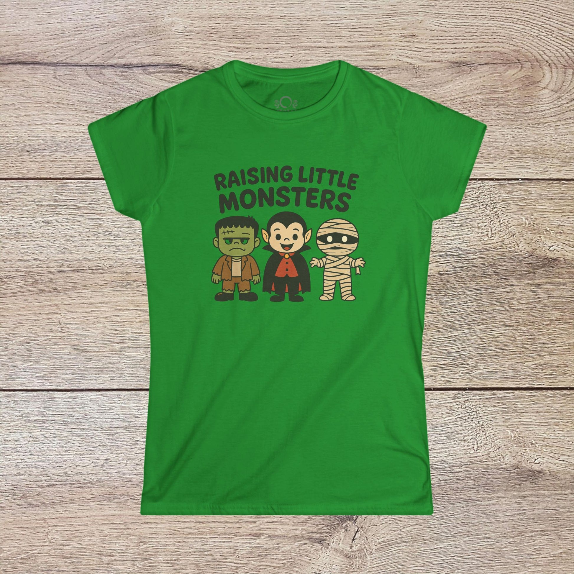 Vibrant green Halloween Family T-Shirt displaying fun cartoon characters of a monster, Dracula, and a mummy, featuring the phrase 'Raising Little Monsters'. Perfect kids tee for Halloween parties.