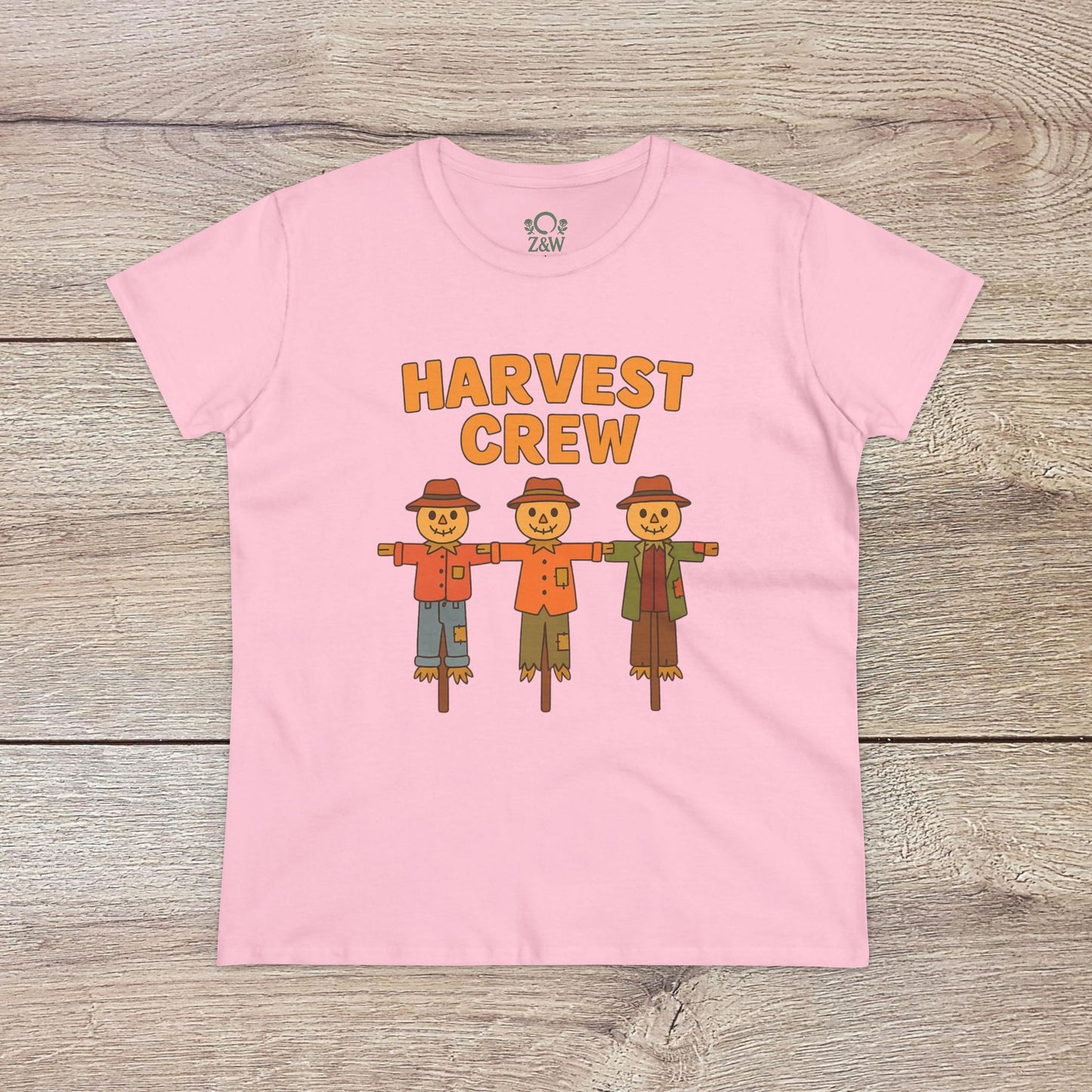 Harvest Crew Halloween T-Shirt in light pink adorned with friendly scarecrow graphics and the words 'Harvest Crew'. Designed for comfort from 100% ring-spun cotton, this shirt supports eco-friendly fashion.