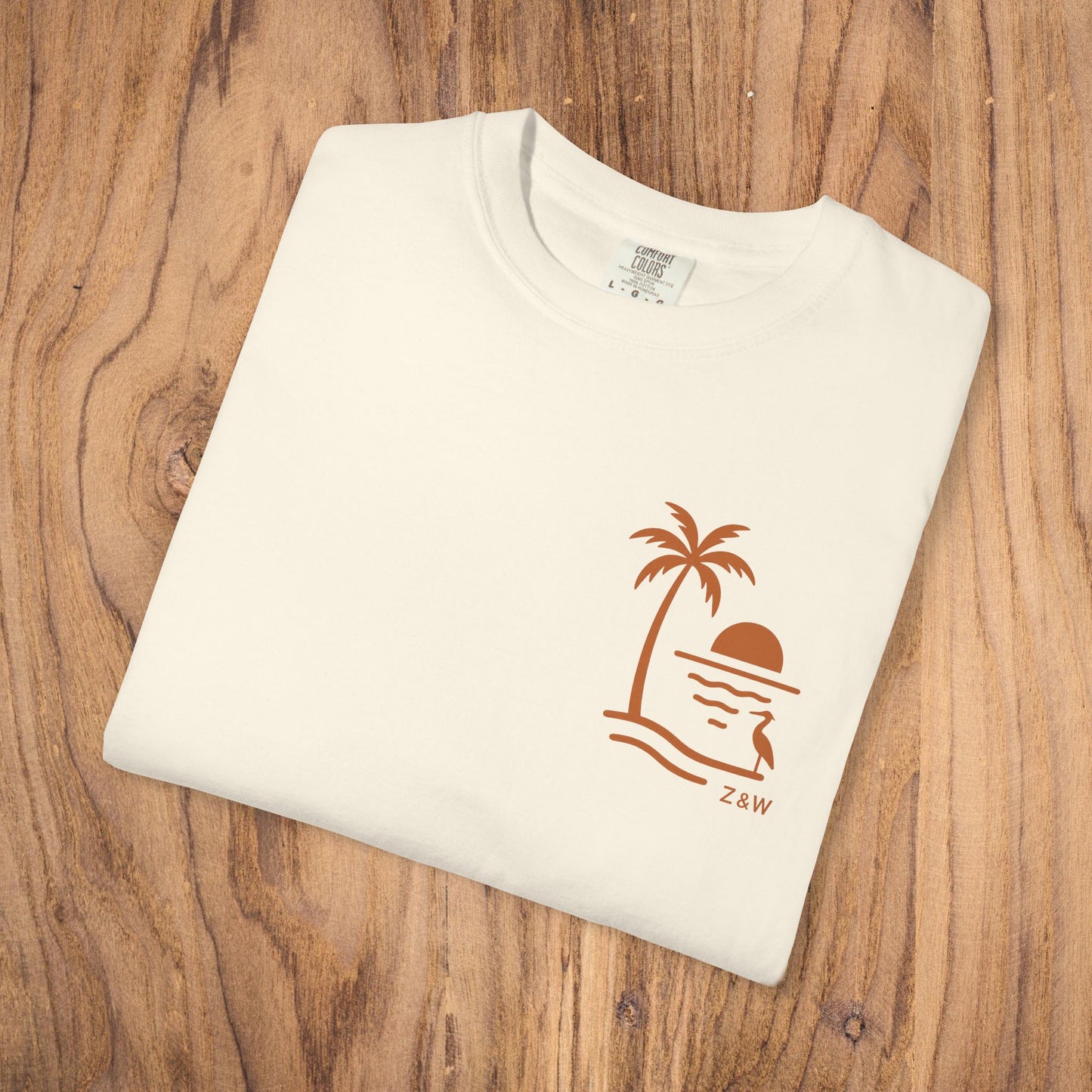 Unisex Sunset Palm Tree T-Shirt displayed in cream color, showcasing a stylish palm tree design, vibrant garment-dyed cotton tee perfect for casual outings.