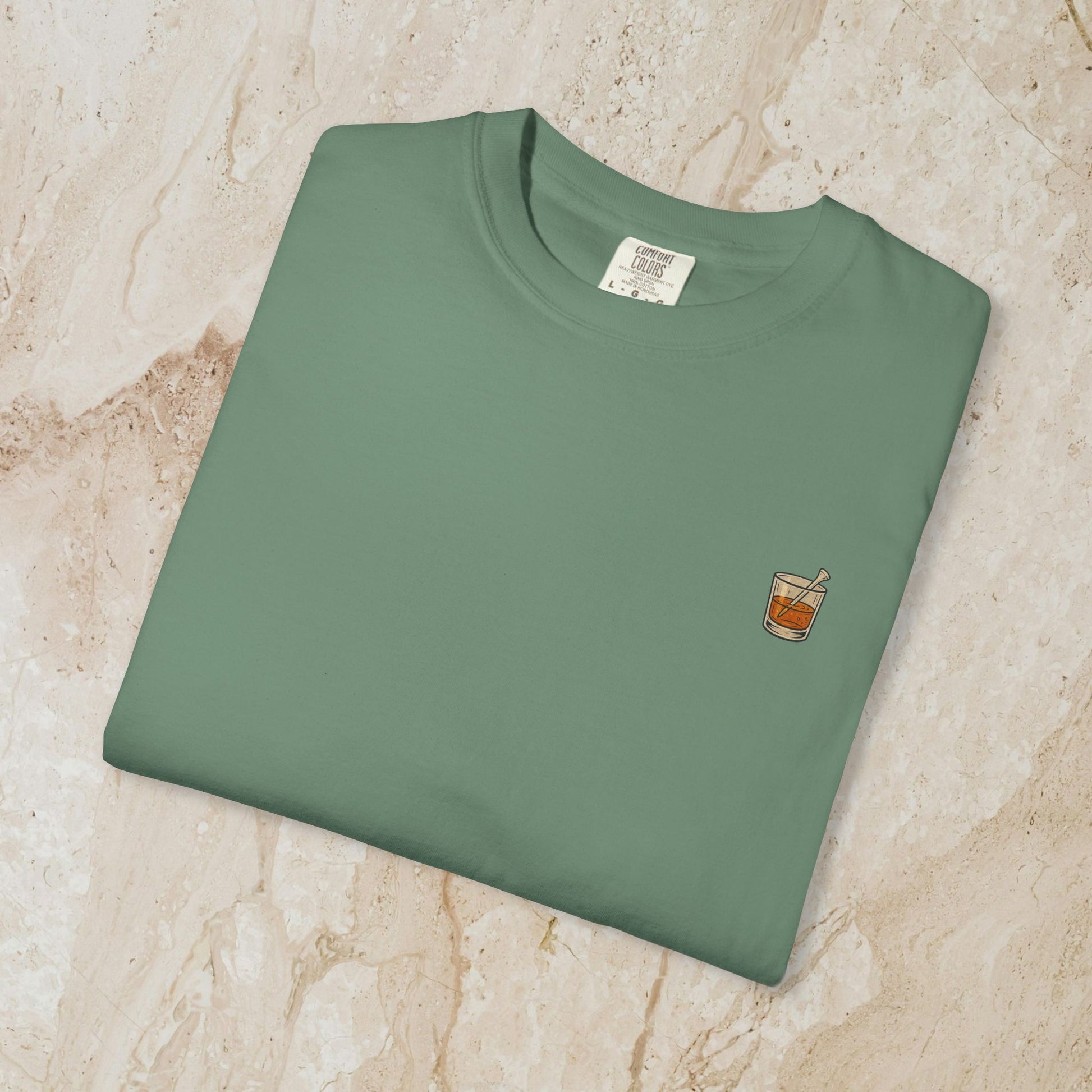 Golden Whiskey Dog Tee laid flat, featuring a subtle left chest pocket and a smooth texture, made from 100% high-quality cotton in a relaxing green color.