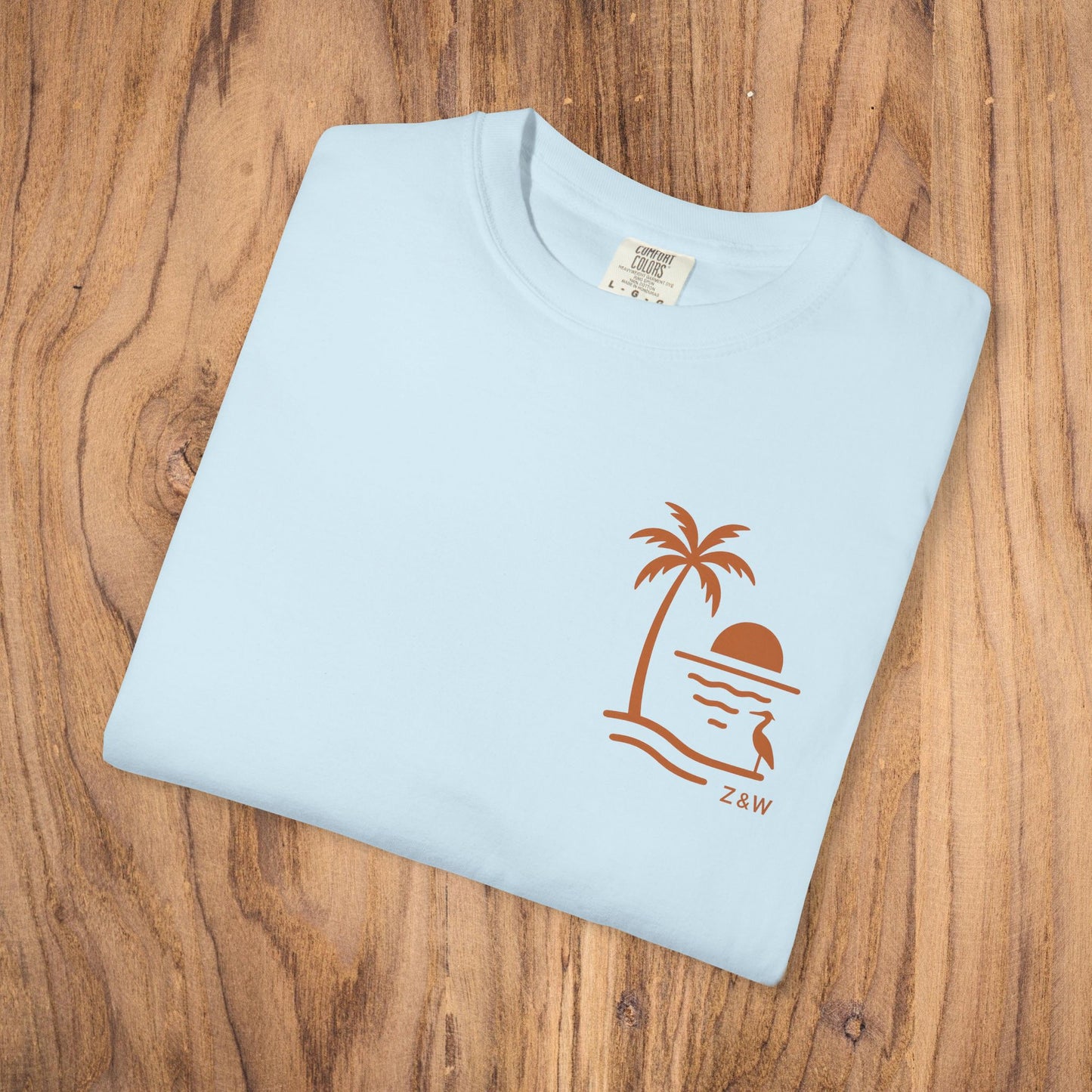 Unisex Sunset Palm Tree T-Shirt - Vibrant Garment-Dyed Cotton Tee for Men & Women in Light Blue featuring a unique palm tree and sunset graphic.