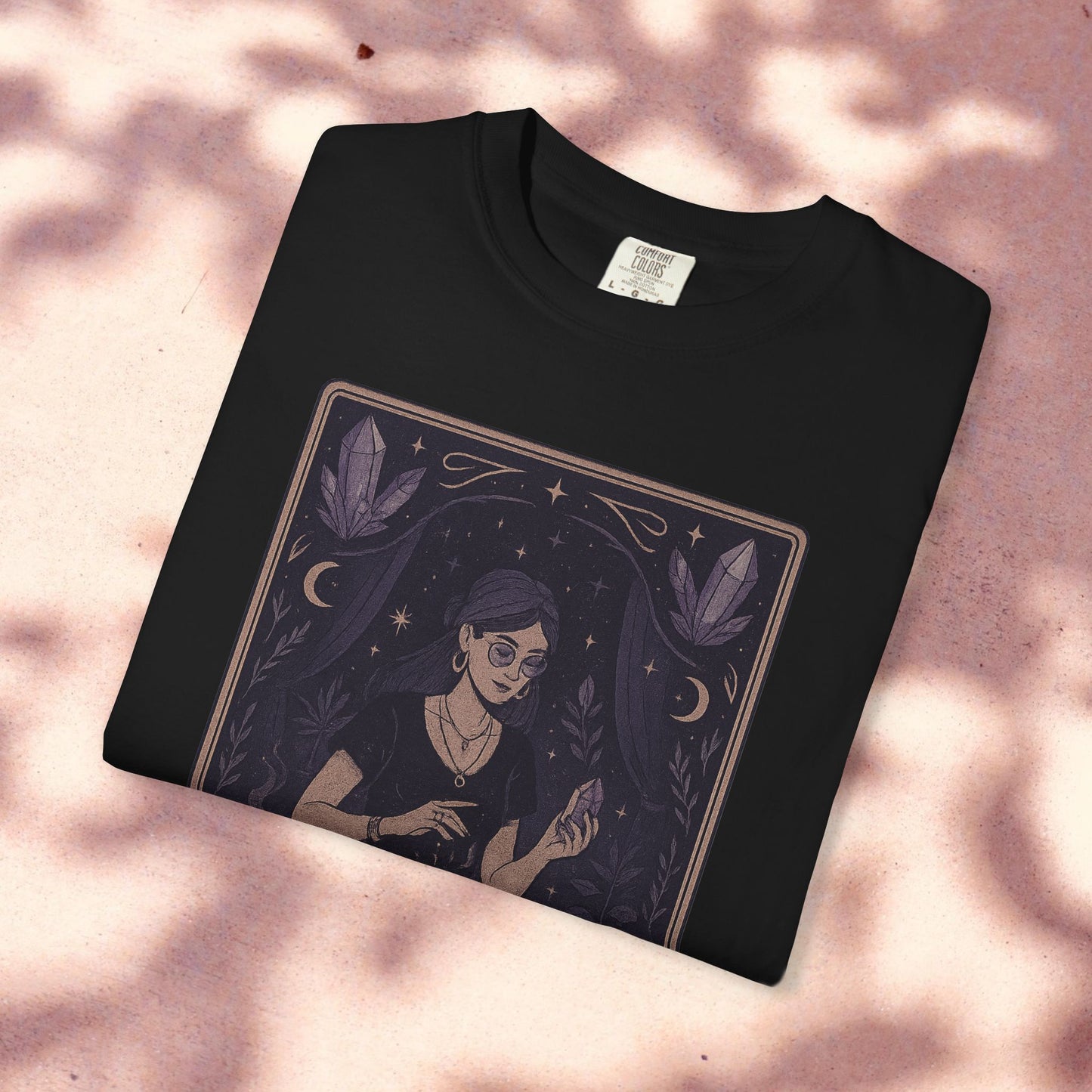 Folded Intuitive Tarot Tee showcasing a unique garment-dyed design of a woman with tarot cards, crafted from soft 100% cotton.