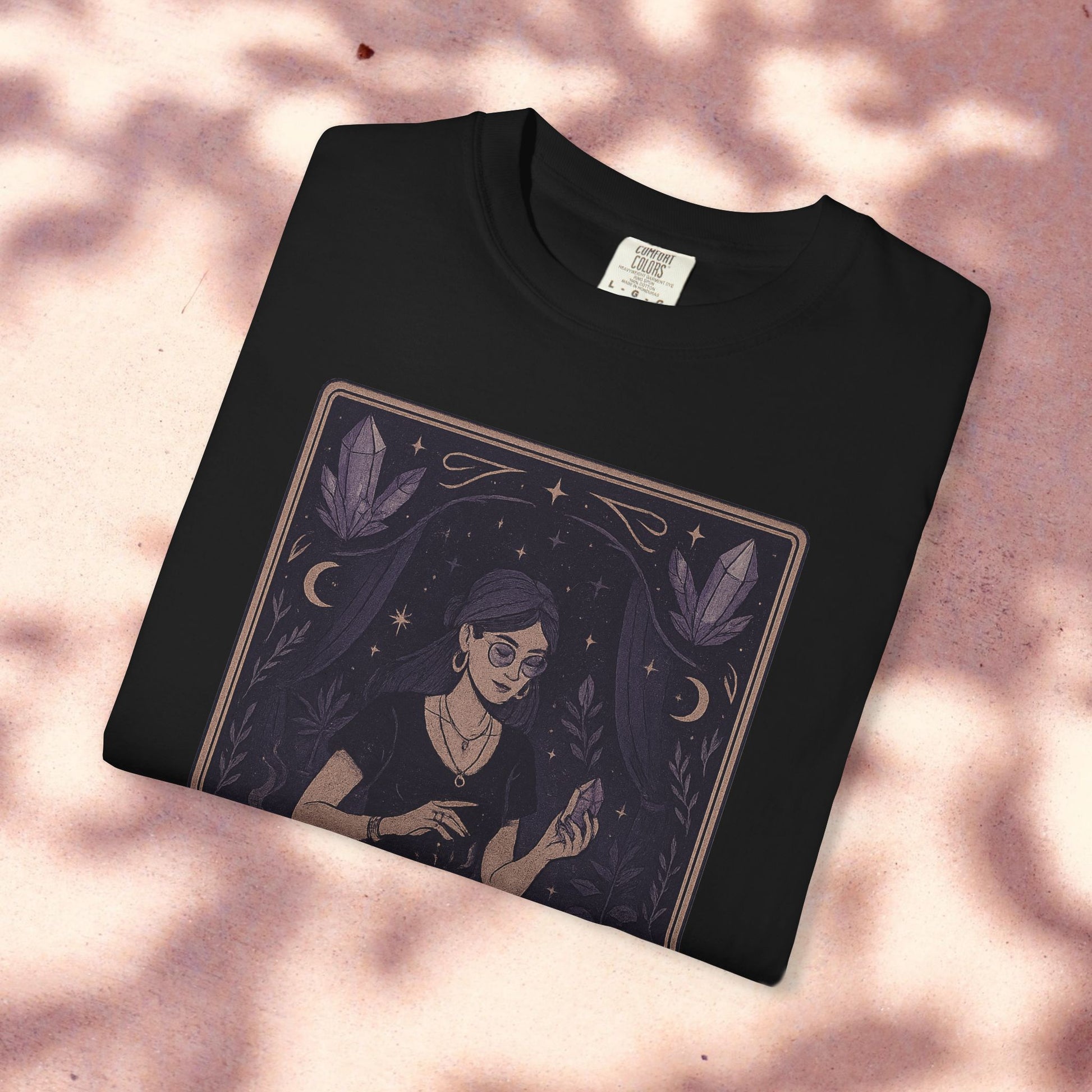 Folded Intuitive Tarot Tee showcasing a unique garment-dyed design of a woman with tarot cards, crafted from soft 100% cotton.