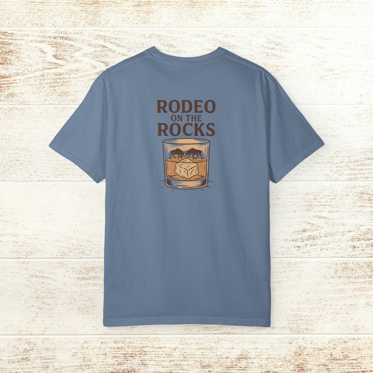Back view of the Rodeo On The Rocks Tee in light blue, featuring a whiskey glass design with 'RODEO ON THE ROCKS' text.