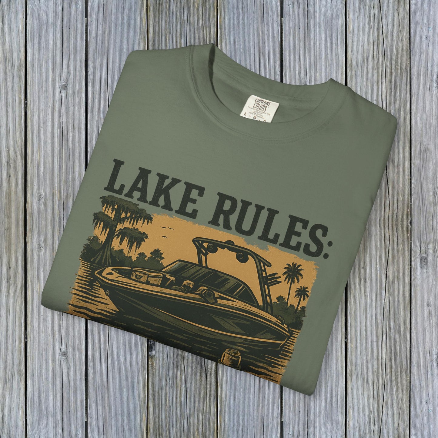 Front view of Unisex Garment-Dyed Lake Rules Tee in green showcasing a boat illustration with 'Lake Rules:' text, made from soft vintage fabric.