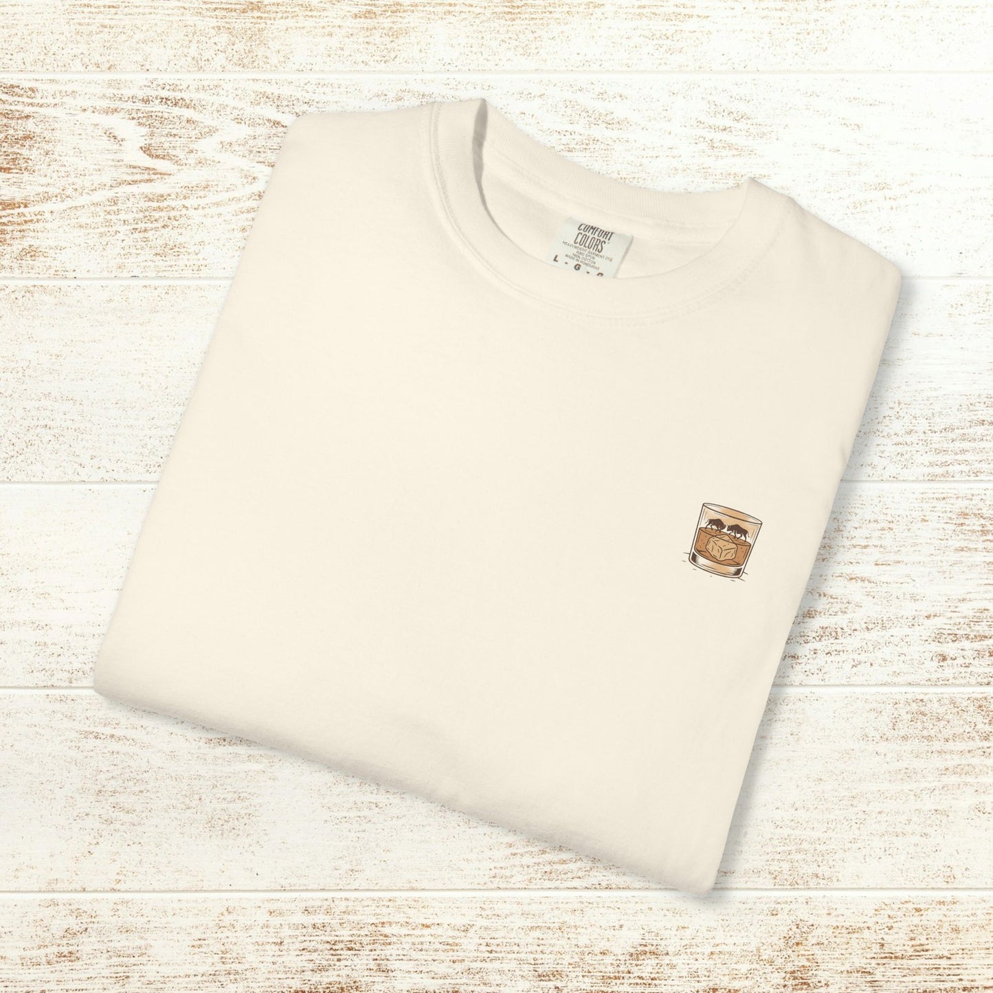 Rodeo On The Rocks Tee - Folded beige t-shirt featuring a drink design, representing soft 100% US cotton and unique garment-dyed style.