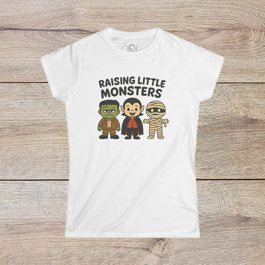 Halloween Family T-Shirt featuring cute cartoon characters, including a Frankenstein monster, Dracula, and a mummy, with the text 'Raising Little Monsters'. Perfect kids tee for parties and costumes.