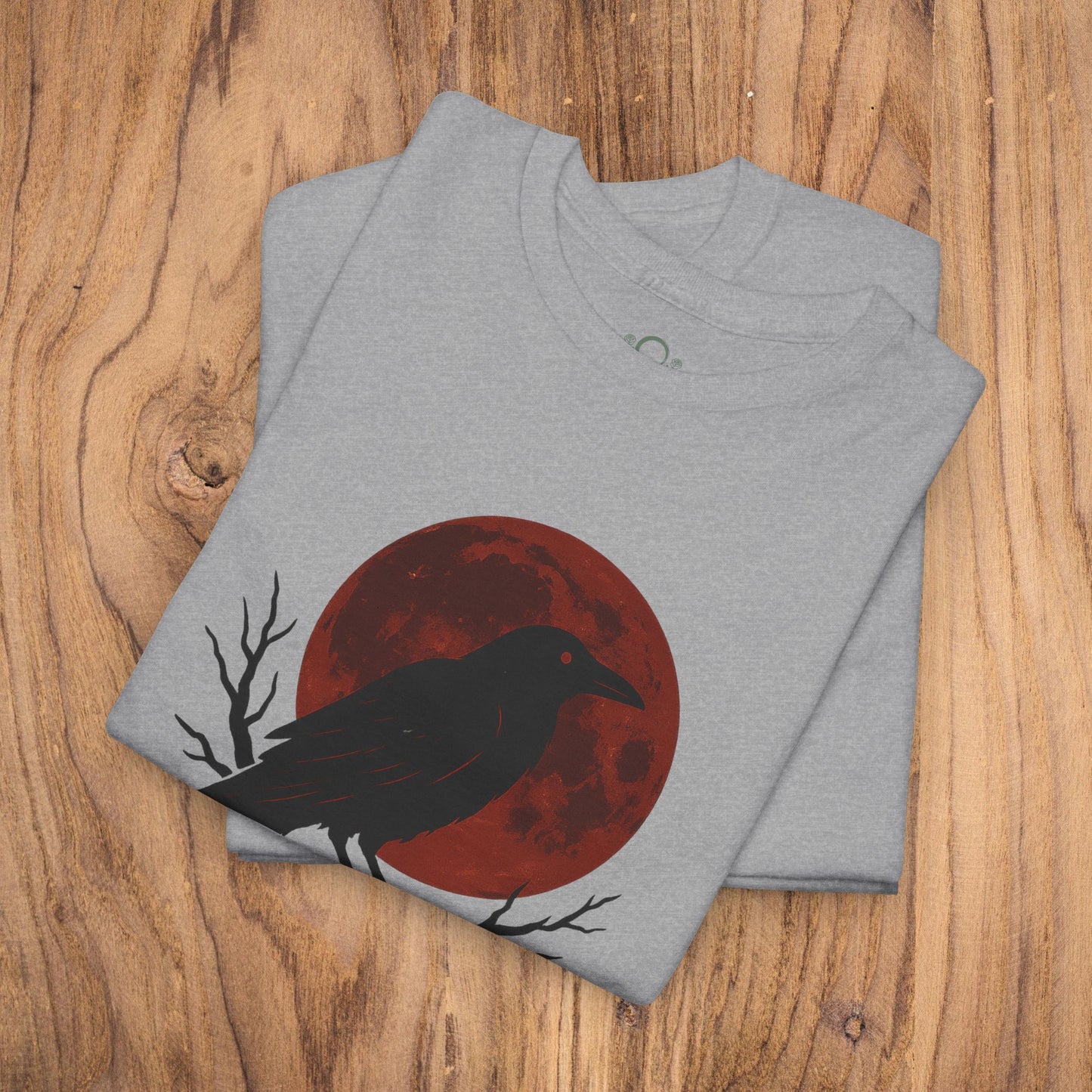 Gothic Raven T-Shirt featuring a striking raven silhouette against a red moon. Perfect heavy cotton tee for Halloween, a unique and spooky gift, ideal for casual fall fashion.