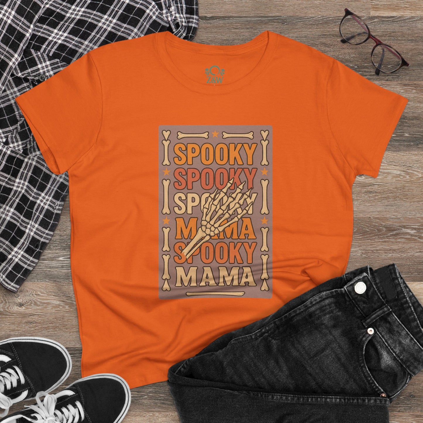 Casual styling of the Spooky Mama Tee in orange, paired with black jeans and a flannel shirt, demonstrating its versatile design for festive occasions.
