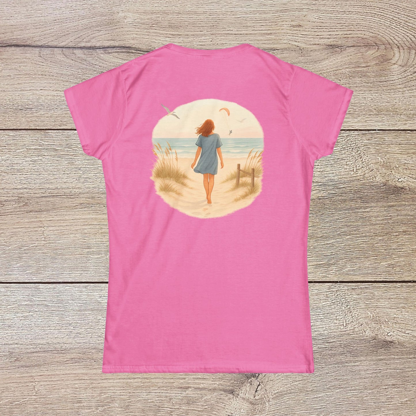 Back view of a woman walking along the beach in a pink Women's Coastal Spirit Midweight Cotton Tee, capturing the essence of coastal living and casual style.