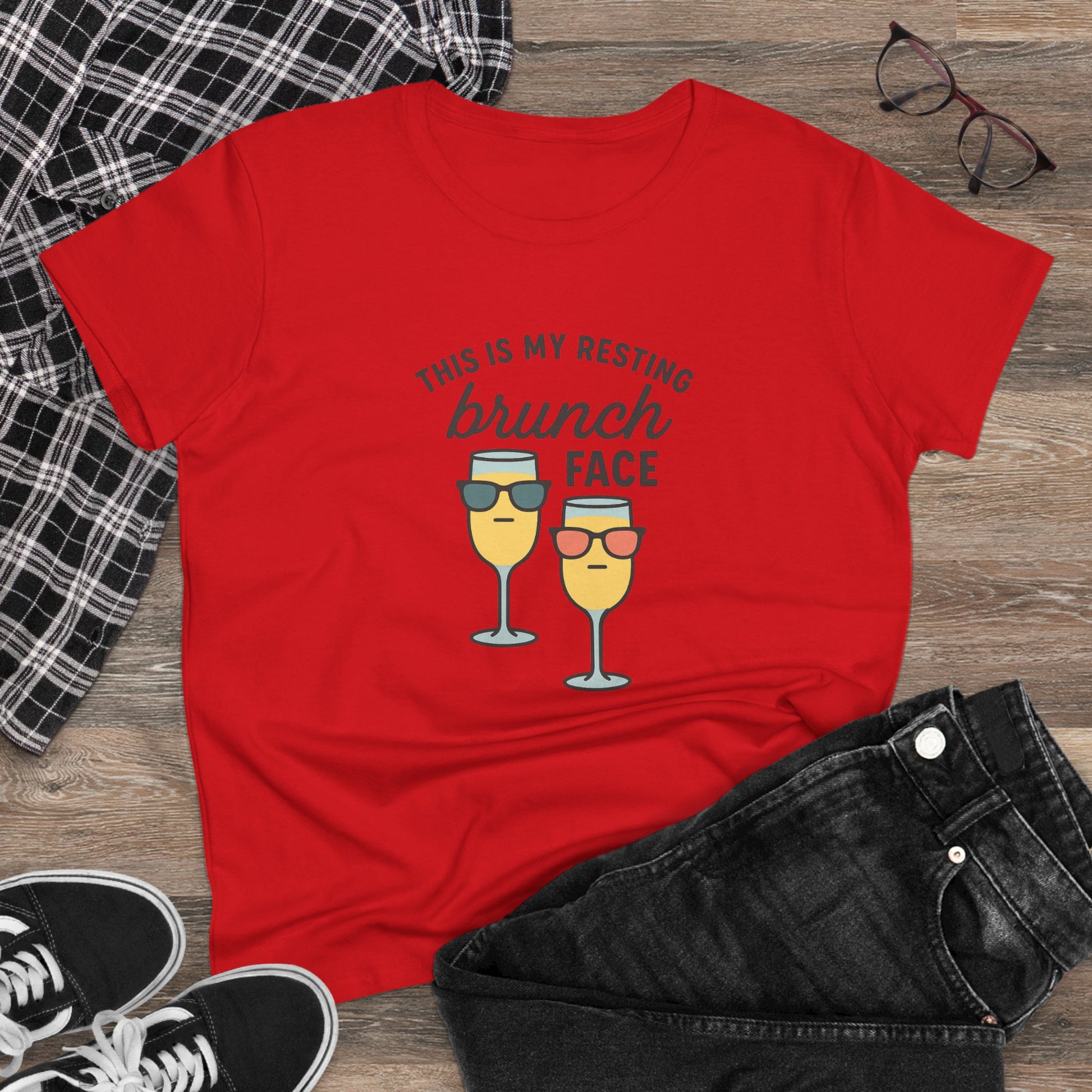 Casual Women's Premium 100% Cotton Brunch Face Tee displayed with denim shorts and sneakers. The vibrant red tee showcases two mimosa glasses with the text 'THIS IS MY RESTING brunch FACE', perfect for stylish and comfortable brunch wear.