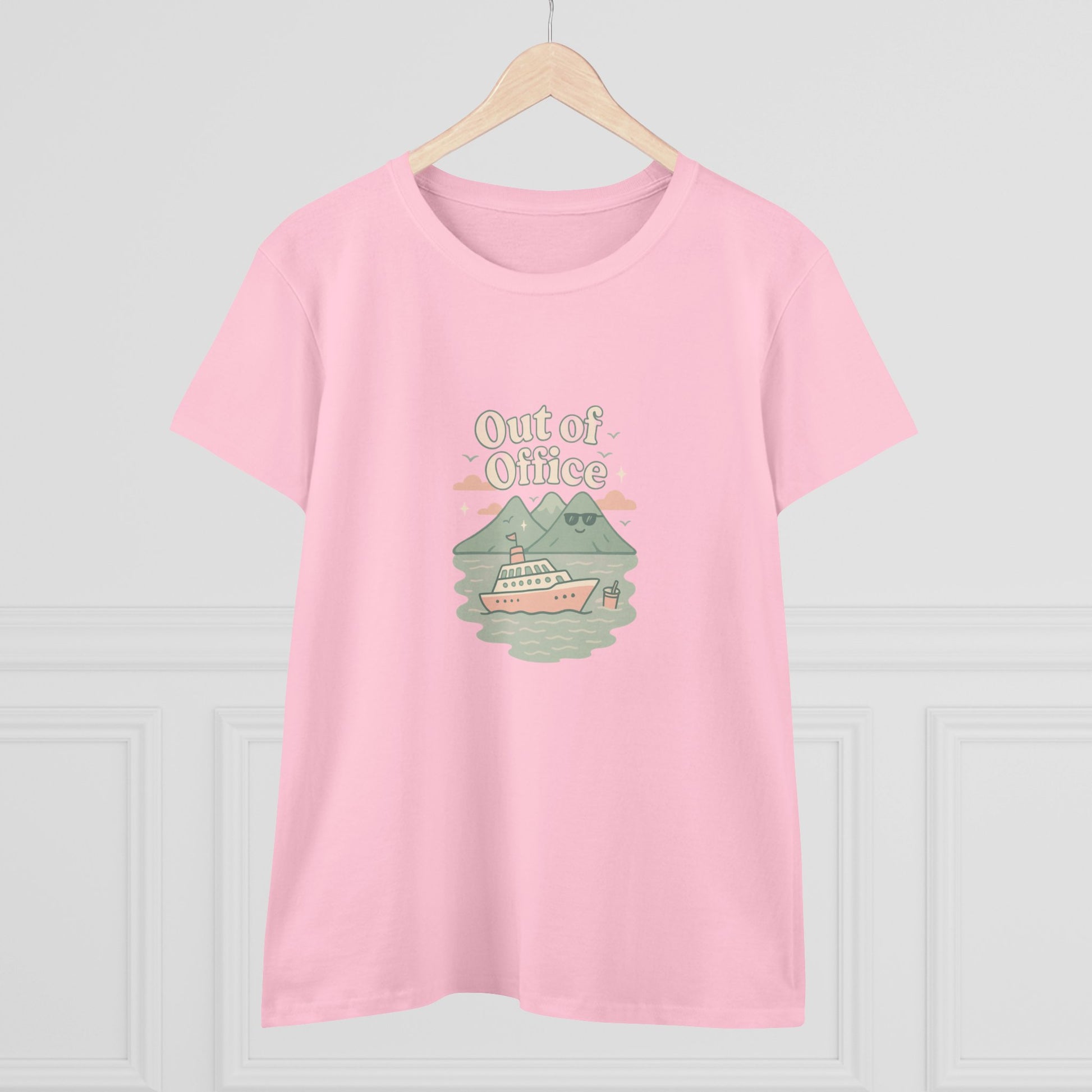Out Of Office Cruise Tee in pink, elegantly displayed on a hanger. Features a charming boat and mountain illustration, great for casual summer attire.