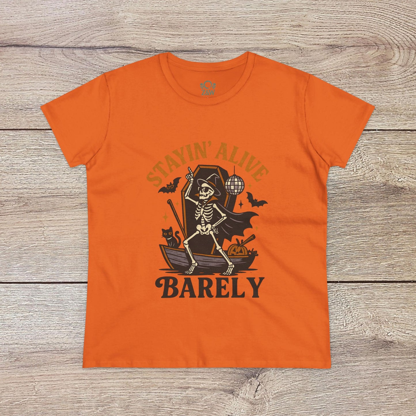 Stayin’ Alive T-Shirt in vibrant orange featuring a playful skeleton design, perfect for Halloween. Unisex softstyle tee ideal for casual wear.