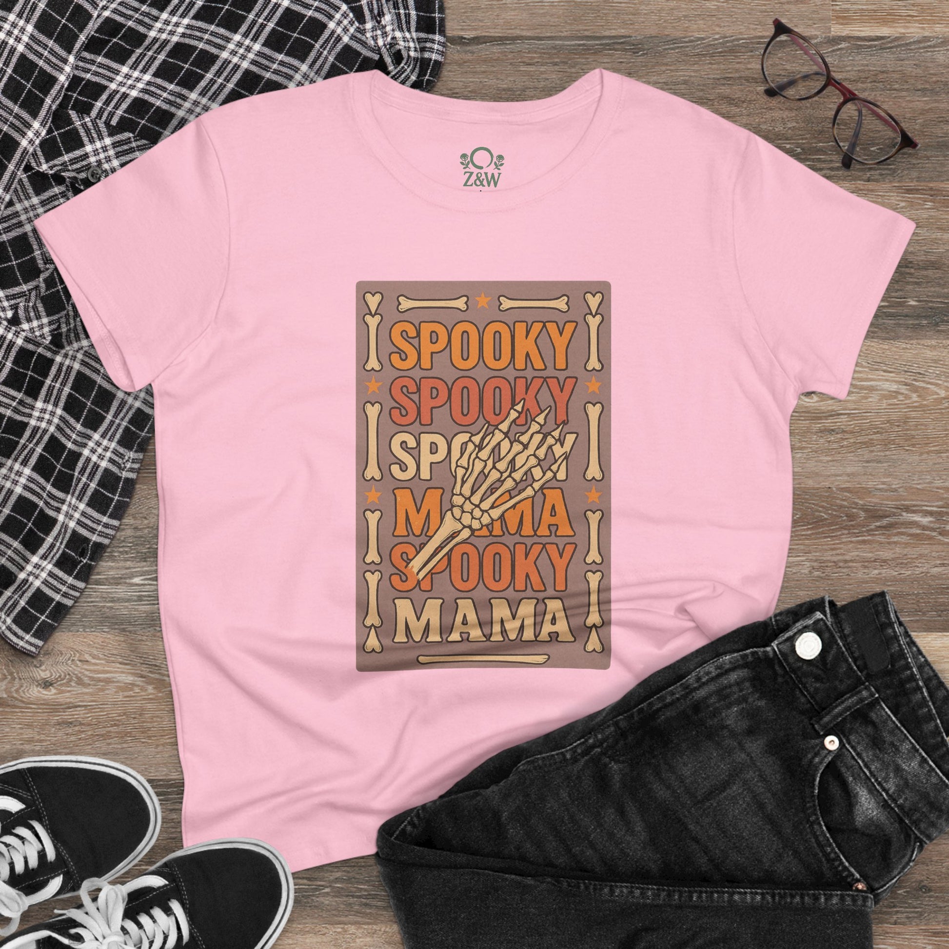 Casual outfit featuring the pink Spooky Mama Tee with a skeleton hand graphic, styled with black jeans and sneakers, emphasizing comfort and style for all occasions.