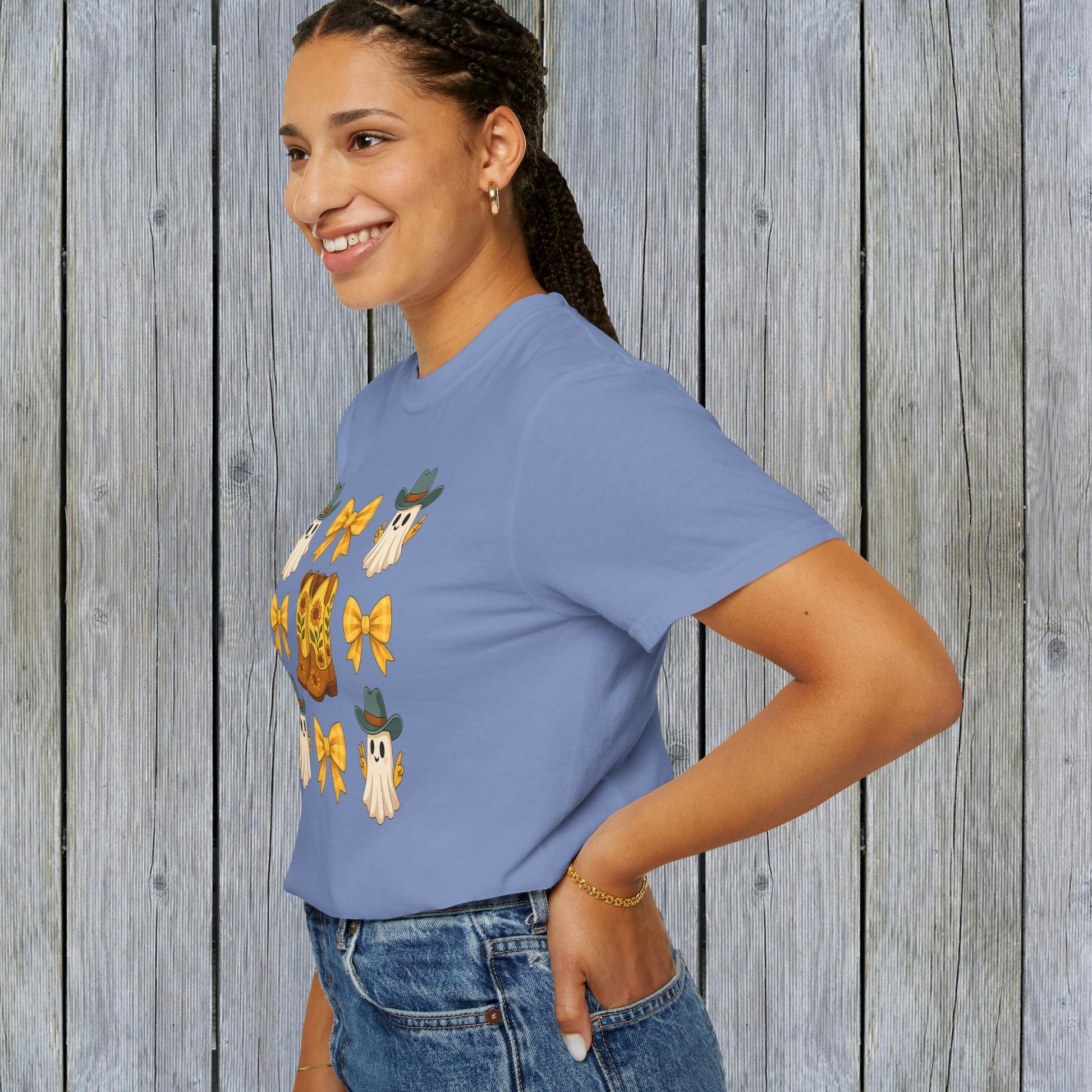Model wearing the Cute Halloween T-Shirt featuring ghosts and cowboy boots, showcasing eco-friendly fabric and a stylish fit for fall fashion.