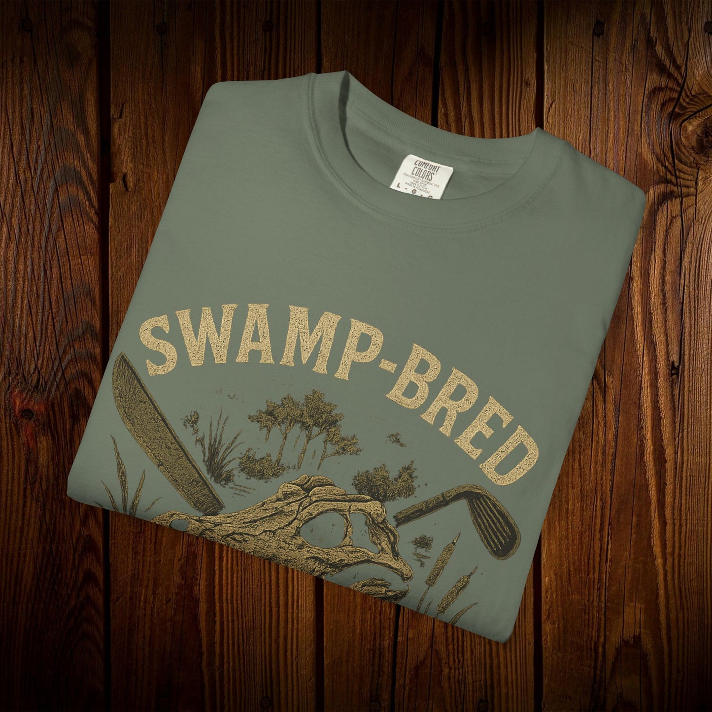 Unisex Swamp-Bred Fairway-Fed Tee in olive green, featuring a detailed graphic with a golf club and swamp imagery, crafted from 100% pre-shrunk US cotton for durability.