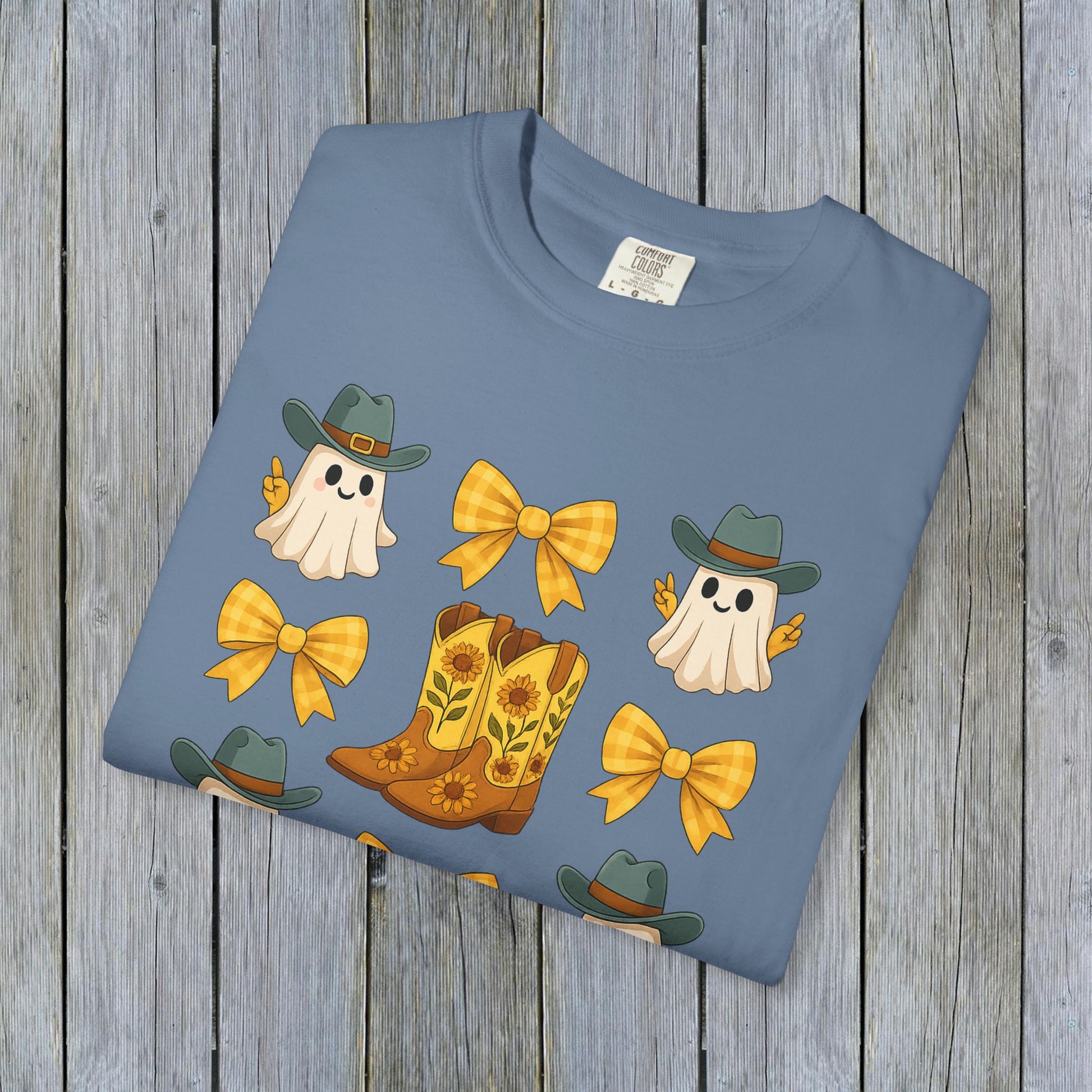 Folded Cute Halloween T-Shirt in blue with charming ghosts and cowboy boots design, made from eco-friendly fabric, perfect for trendy fall fashion.