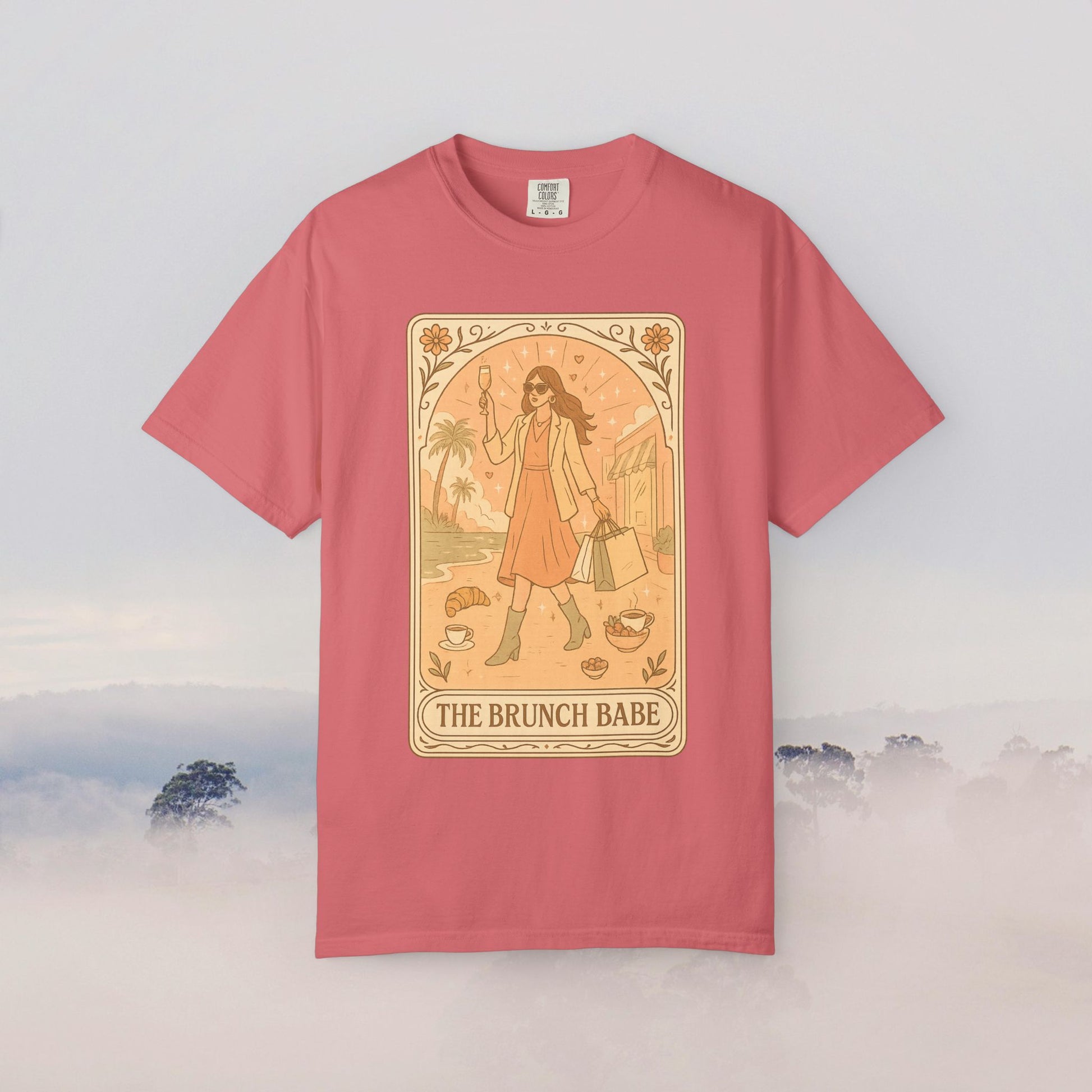 Brunch Babe Tarot Graphic Tee in coral pink, featuring a charming illustration of a woman with shopping bags, ideal for brunch lovers.
