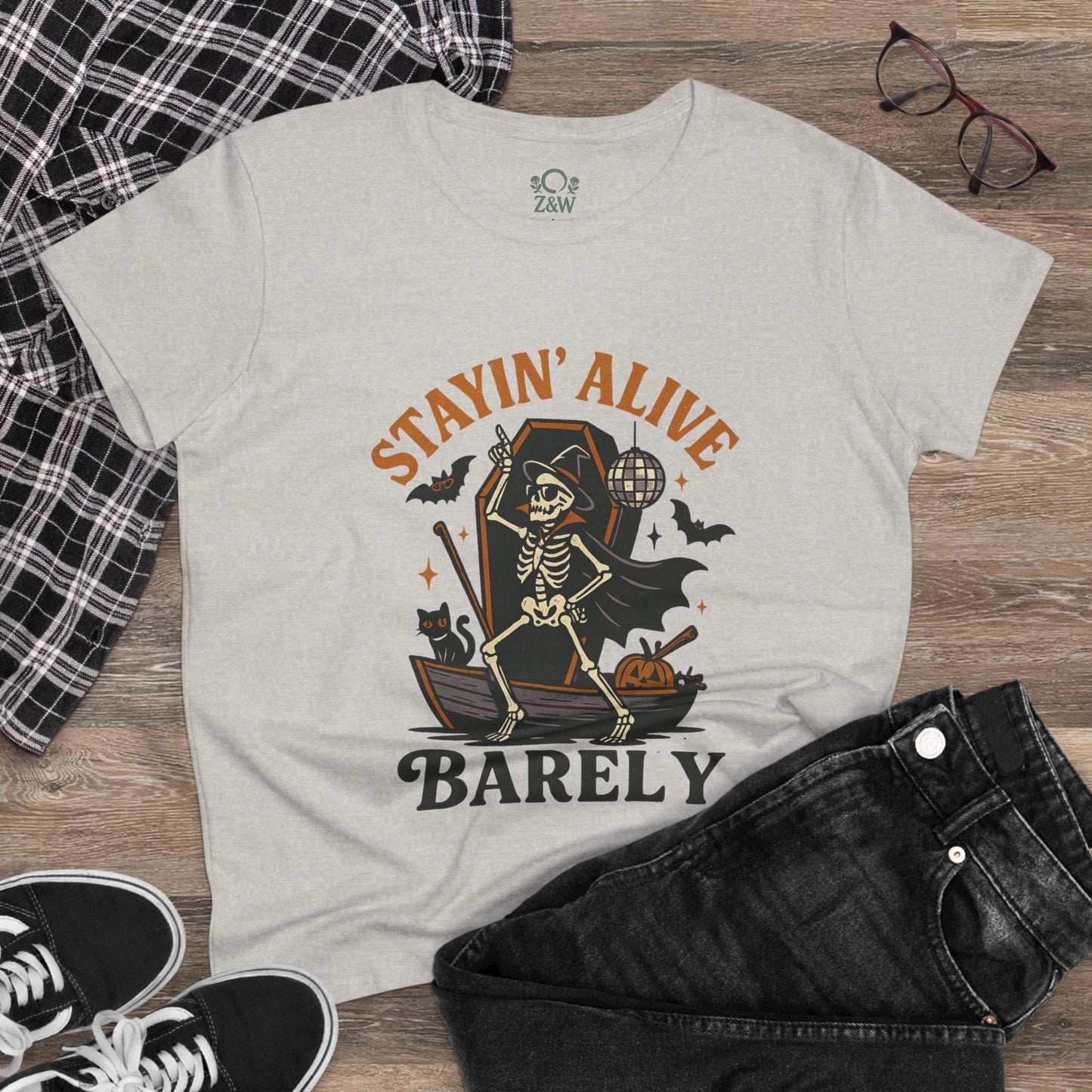 Stayin’ Alive T-Shirt featuring a skeleton on a boat with Halloween elements, perfect for a funny Halloween unisex tee.
