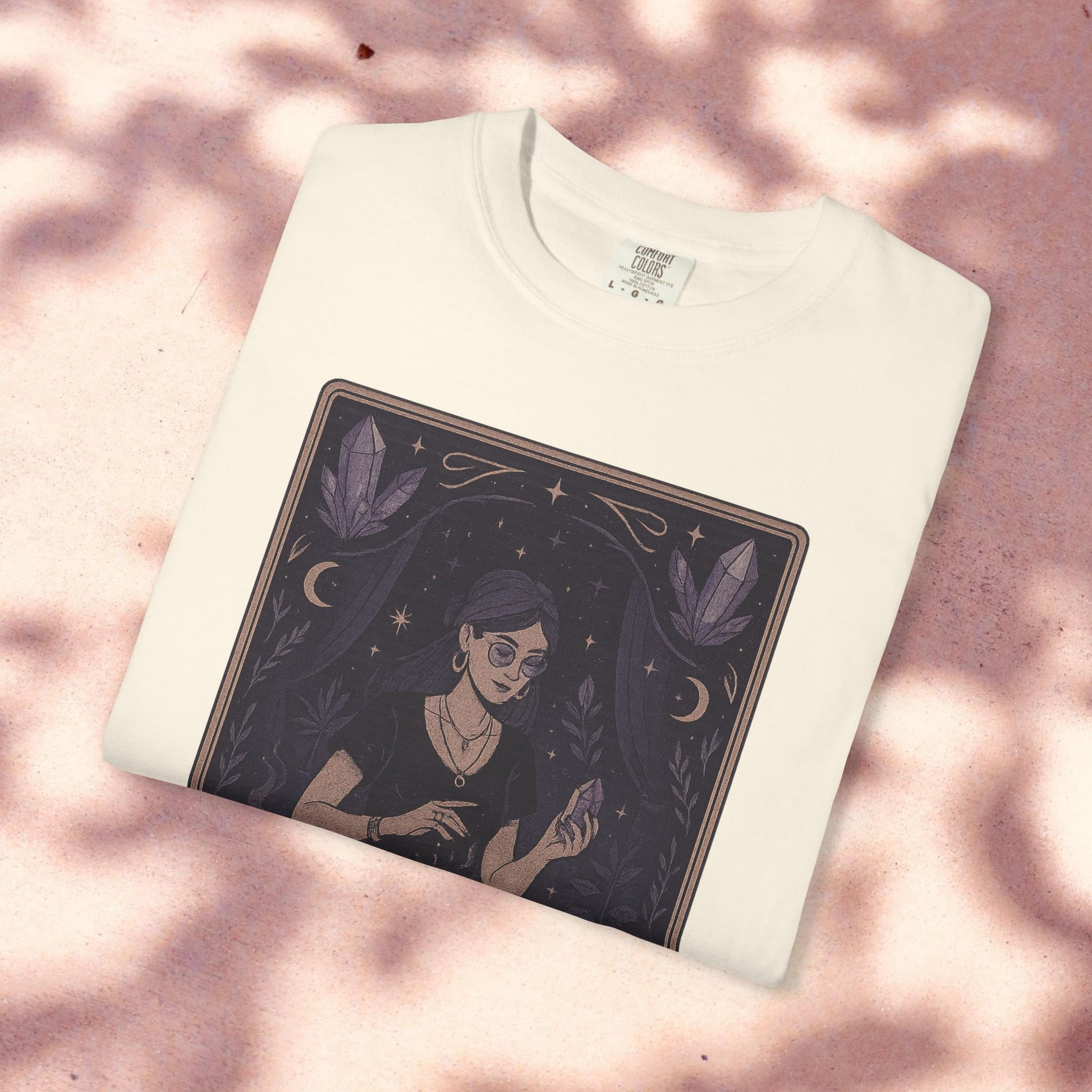 Intuitive Tarot Tee in classic white, shown against a light pink surface, depicting a woman with a crystal, made from 100% high-quality cotton for comfort.