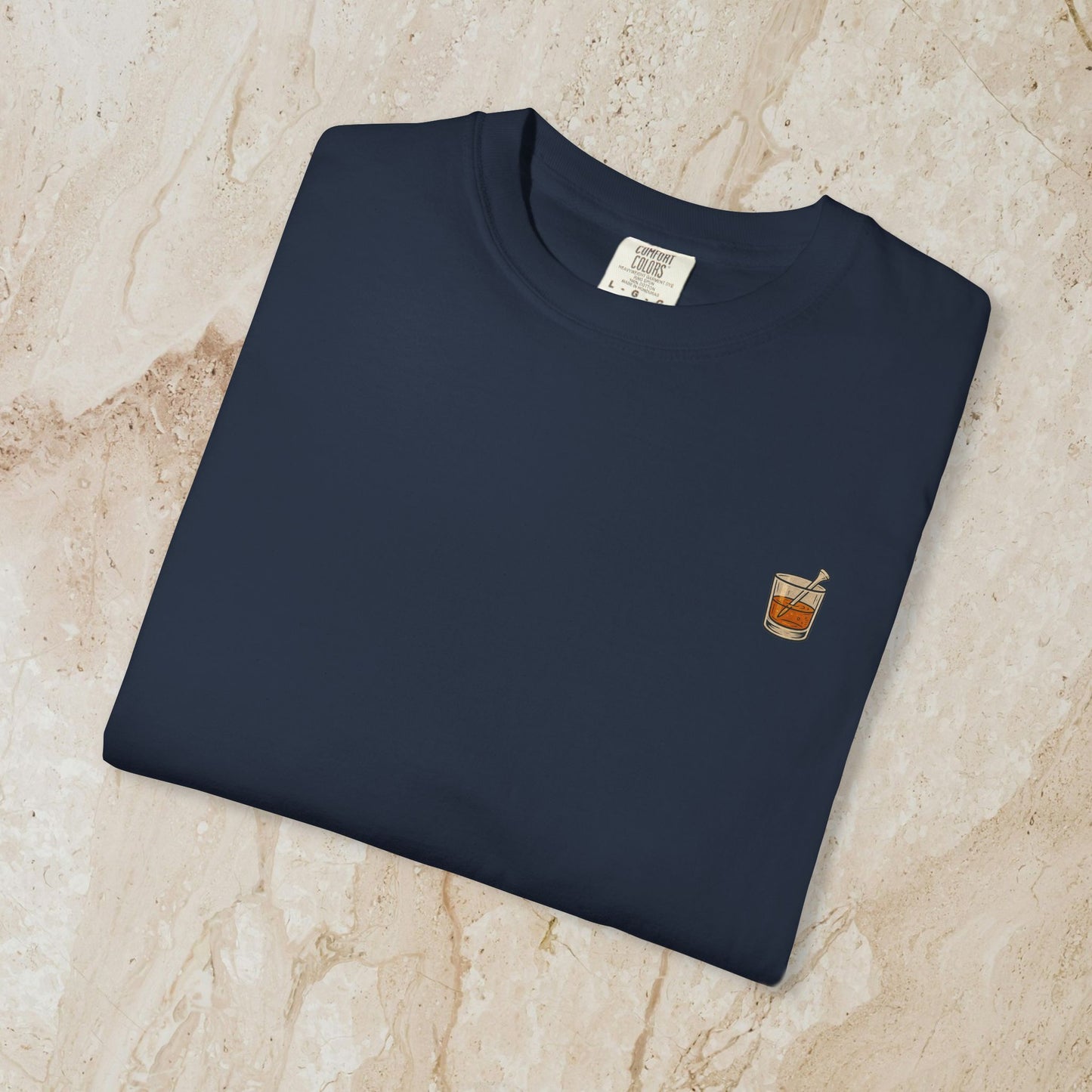 Folded Golden Whiskey Dog Tee in navy color with a small pocket graphic featuring a drink, made of 100% cotton for a relaxed fit and comfort.