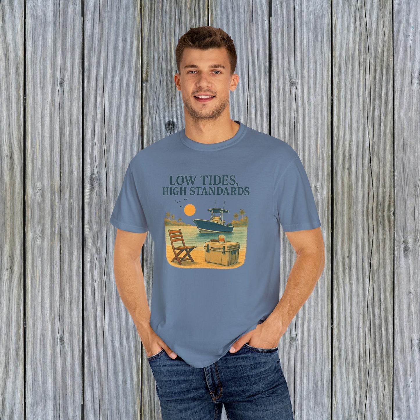 Model wearing the Garment-Dyed Low Tides High Standards T-Shirt in blue, featuring a vibrant beach-themed graphic that captures a relaxed vibe.