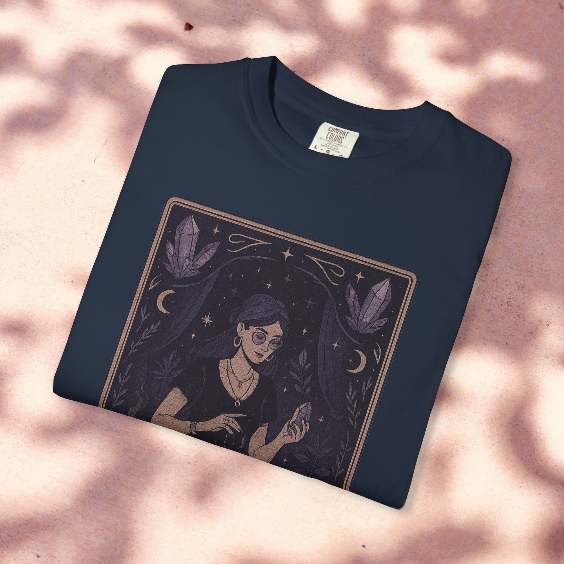 Intuitive Tarot Tee in navy blue on a light pink surface, showcasing a mystical design with a woman holding a crystal, made from high-quality 100% cotton.