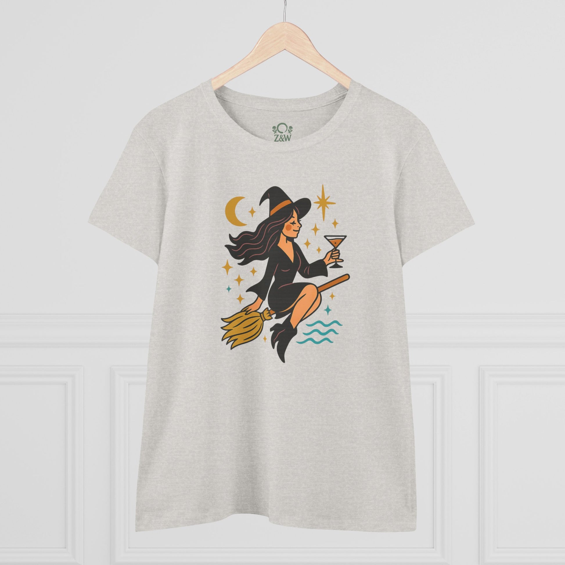 Witchy Night Out Tee featuring a stylish witch flying on a broomstick with a cocktail, crafted from 100% cotton for comfort and durability.