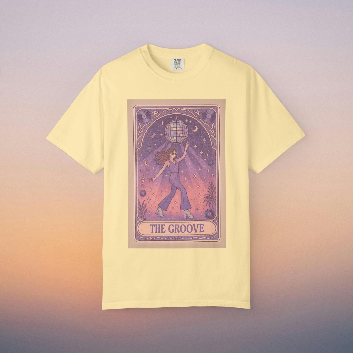 Groove Tarot Graphic Tee in soft yellow, displaying a whimsical design of a person lifting a globe amidst a celestial background. This stylish tee is made from 100% ring-spun cotton, fitting all genders and available in sizes S-4XL.