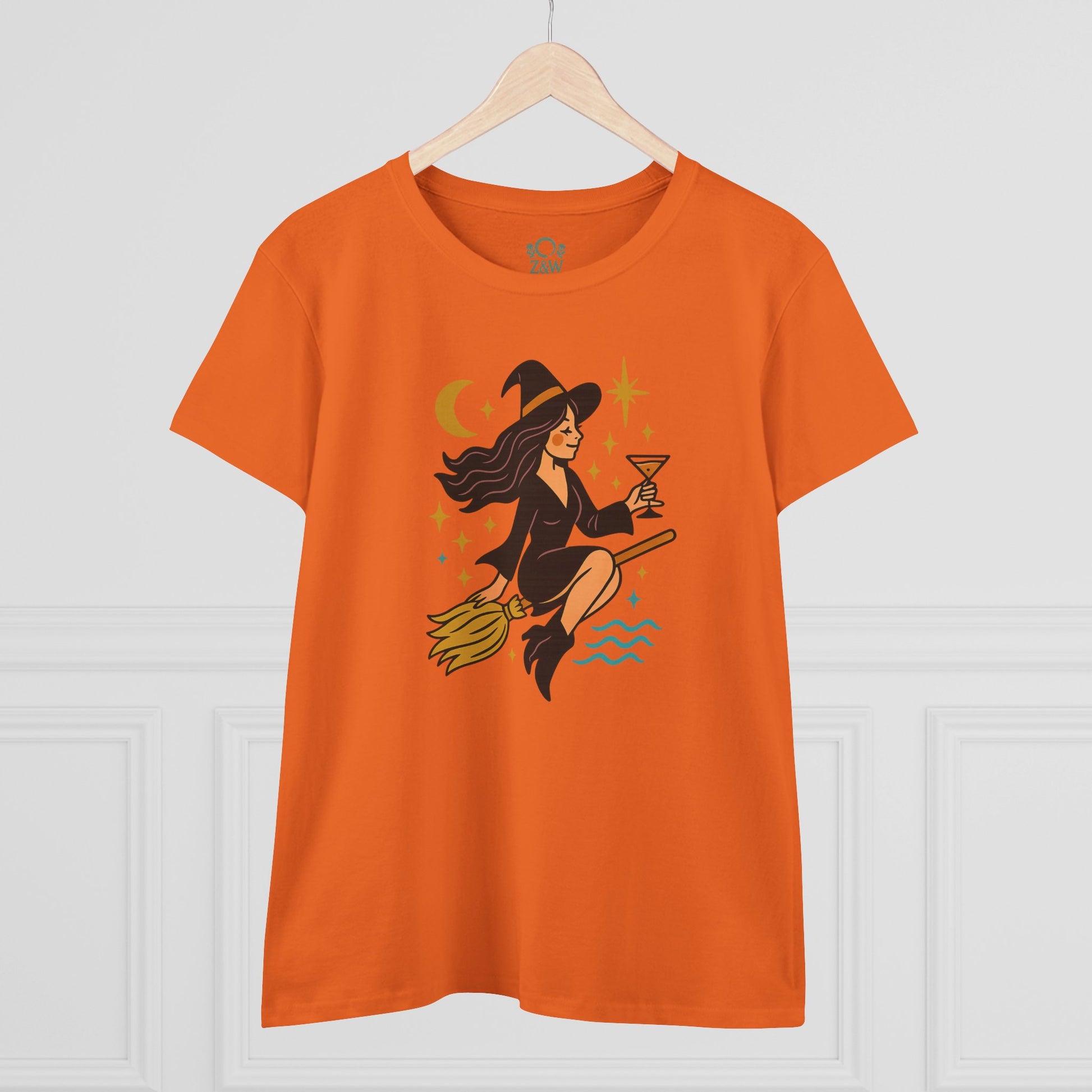 Witchy Night Out Tee in orange with an eye-catching design of a witch on a broomstick, ideal for stylish and ethical fashion.
