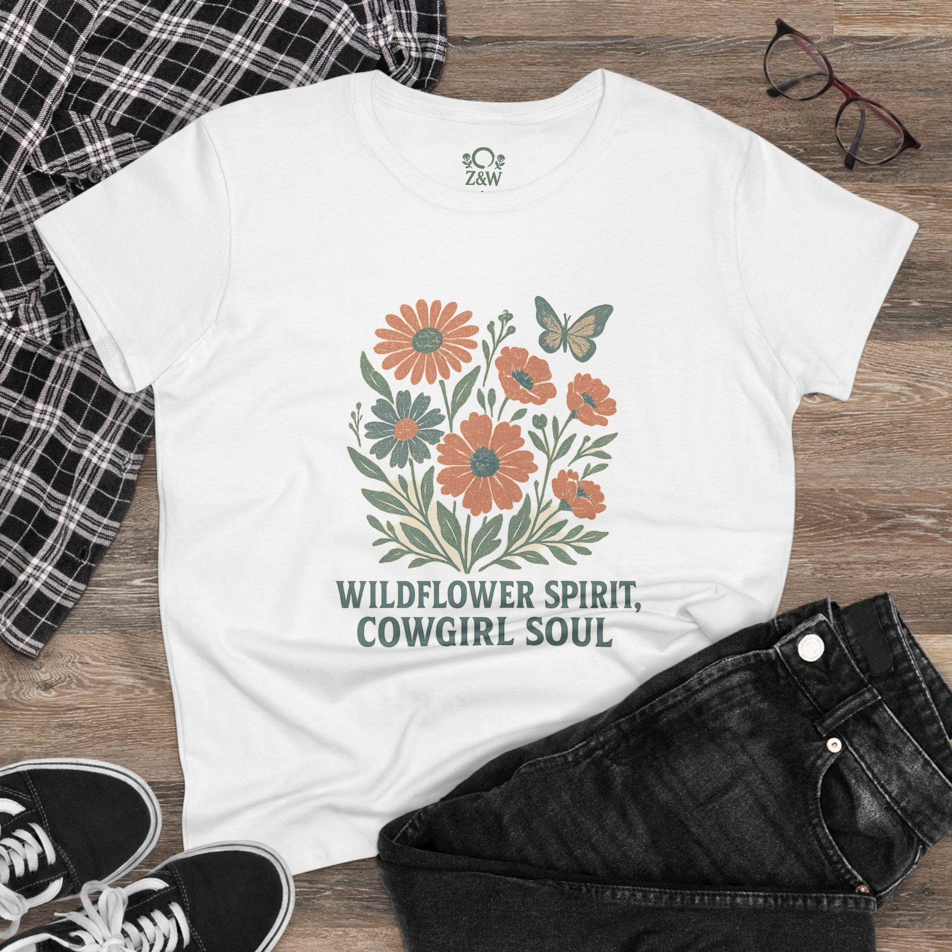 Styled Wildflower Spirit Cotton Tee in white with floral artwork and 'Wildflower Spirit, Cowgirl Soul' text, paired with jeans and accessories for a trendy outfit.