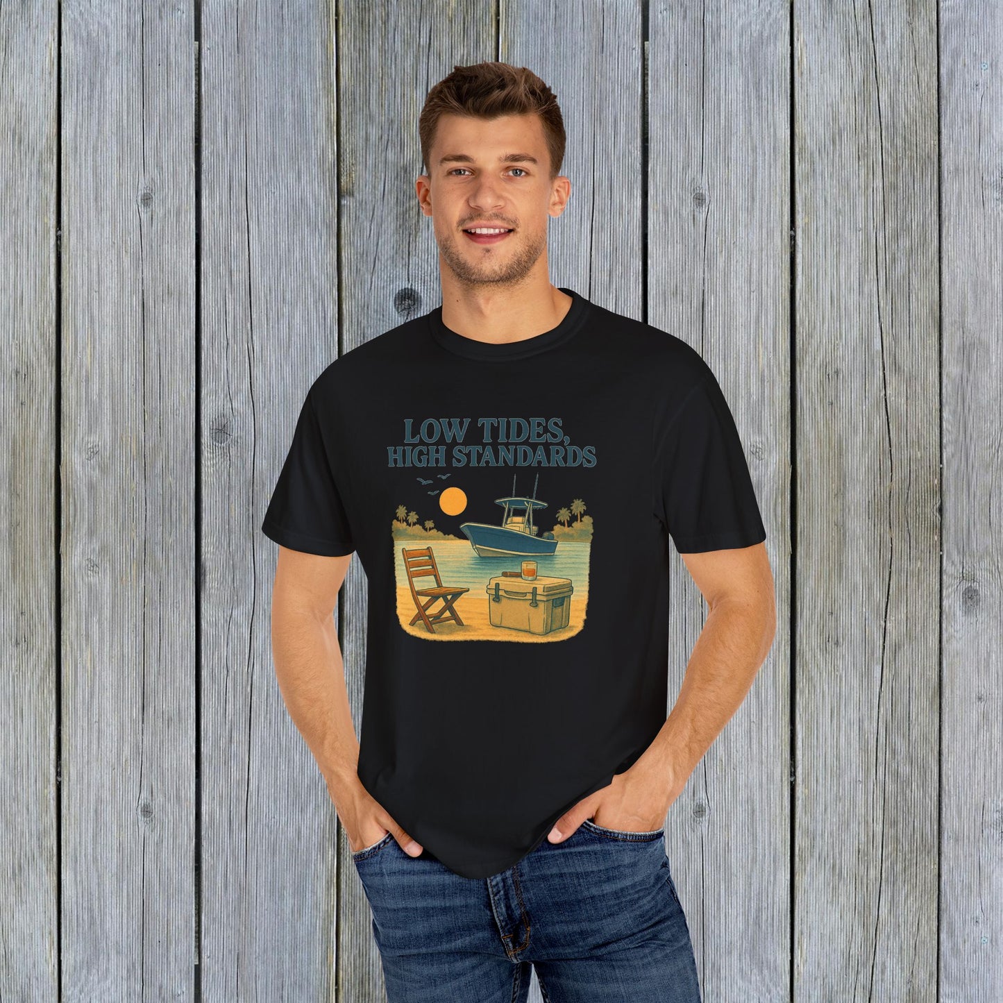 Man wearing Garment-Dyed Low Tides High Standards T-Shirt in black, featuring a boat and sunset design, ideal for beach outings or everyday casual wear.