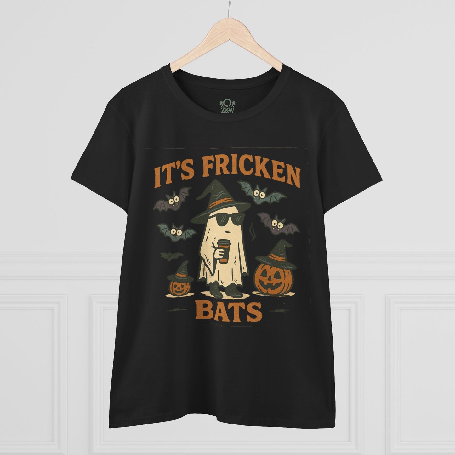 Stylish black Halloween Unisex T-Shirt hanging on display, featuring a fun ghost graphic with bats and pumpkins; made from soft 100% cotton, great for Halloween.