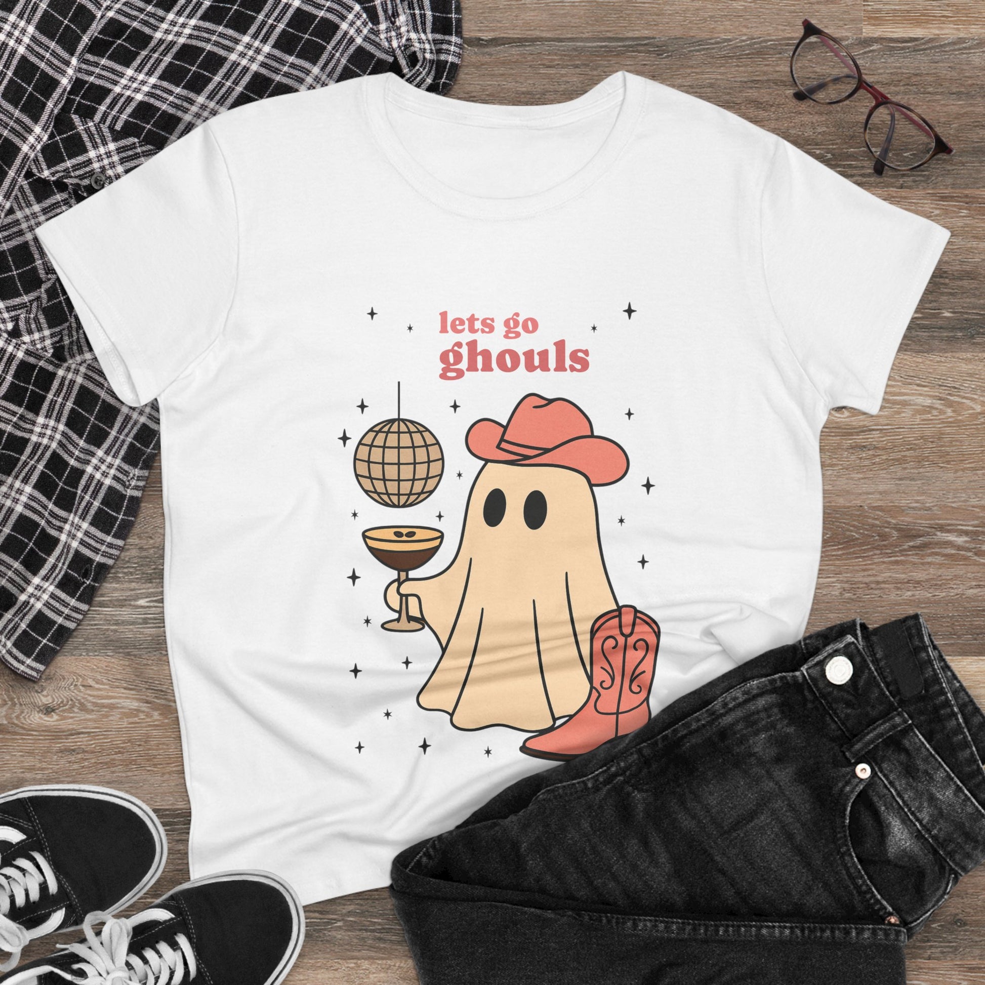 Let's Go Ghouls Tee in white with a charming ghost illustration holding a cocktail and wearing a hat, a must-have for Halloween celebrations.