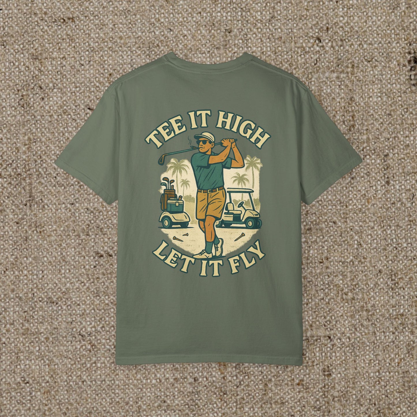 The Tee It High Let It Fly Graphic Tee in an olive green color with an eye-catching golfer graphic on the back, suitable for various occasions.