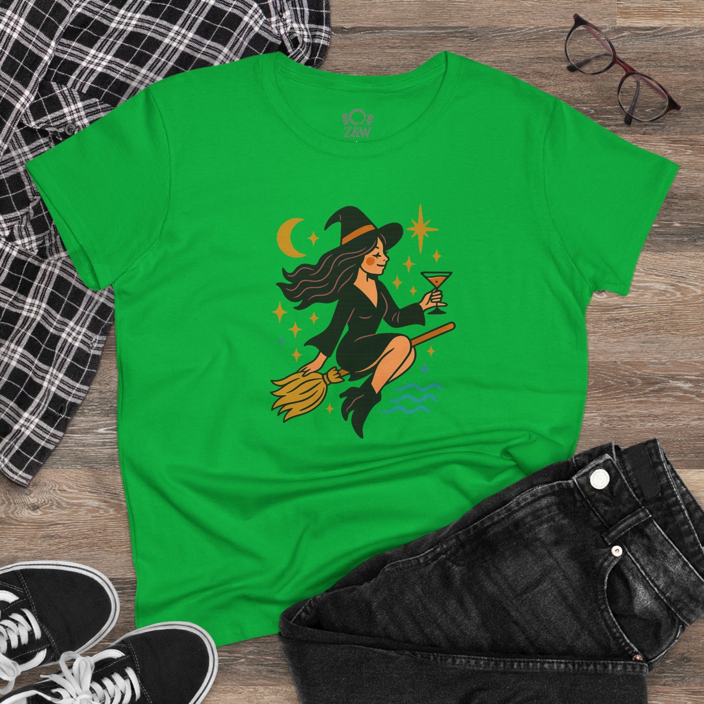 Witchy Night Out Tee - A vibrant green t-shirt featuring a stylish witch riding a broomstick with a cocktail, perfect for adding a fun touch to any outfit.